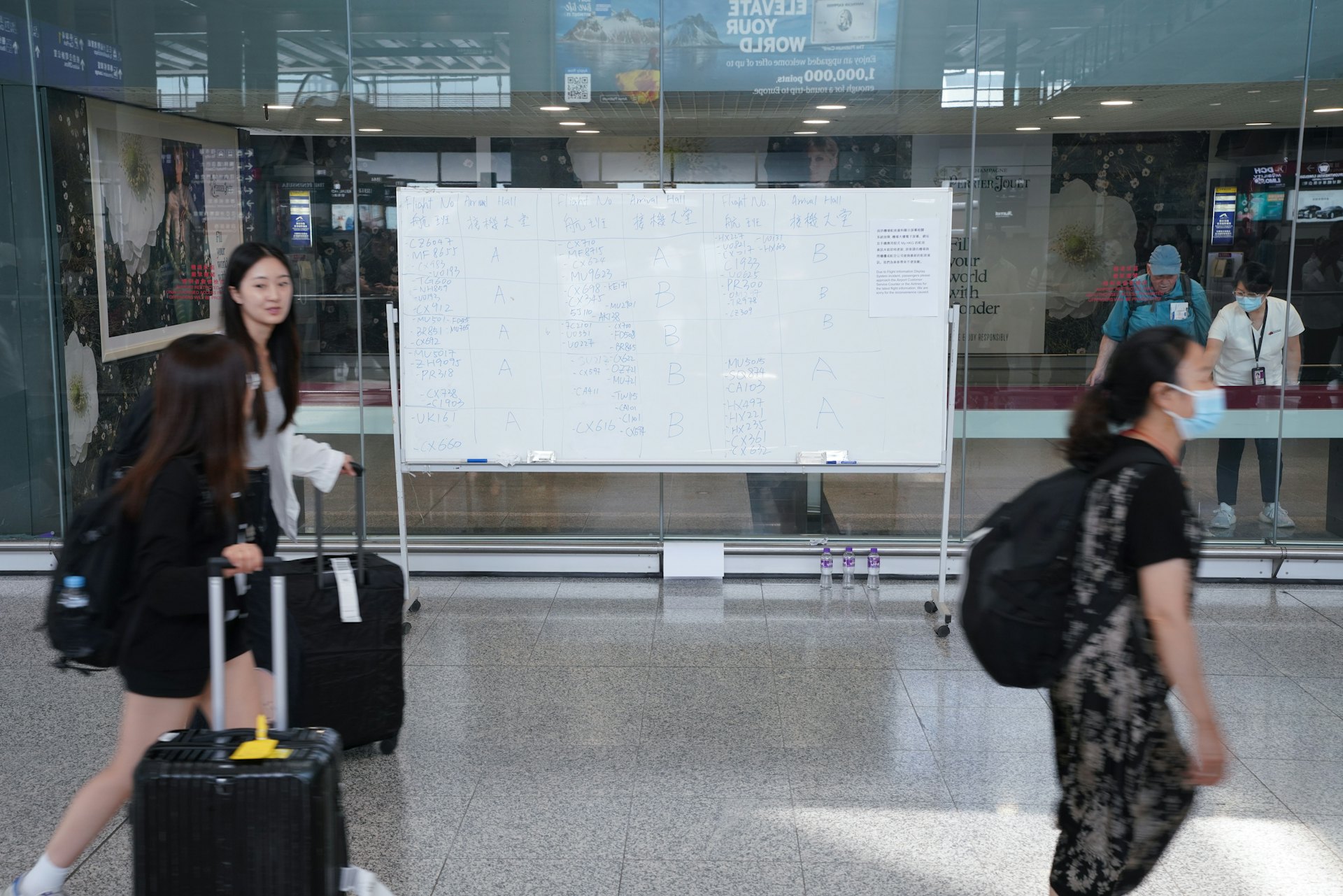 接機大堂則豎立白板,手寫抵港客機出閘位置。(黃浩謙攝) 接機大堂則豎立白板,手寫抵港客機出閘位置。(黃浩謙攝)
