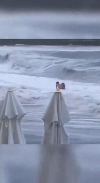 俄罗斯情侣日前到海边拍拖，热吻后女子被巨浪卷走。（影片截图）
