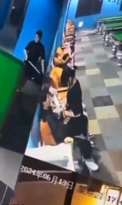 年輕男女當眾激戰期間,附近也有其他客人正在打桌球。(網上影片截圖)