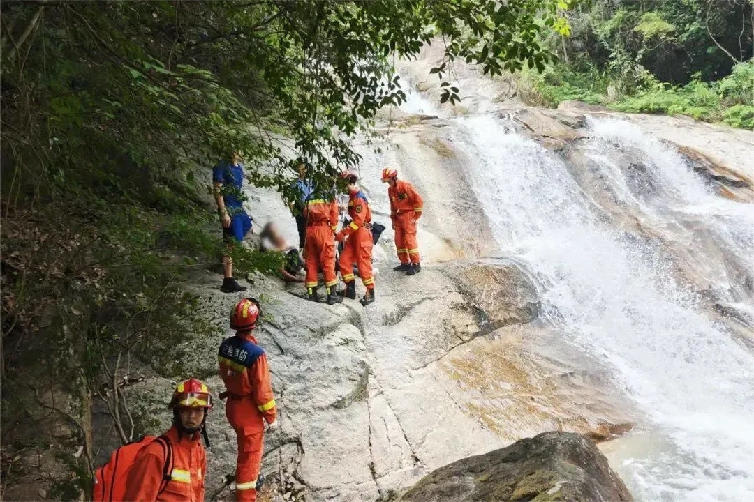 該名男遊客頭纏白布躺在瀑布邊,失去意識。(新聞晨報)