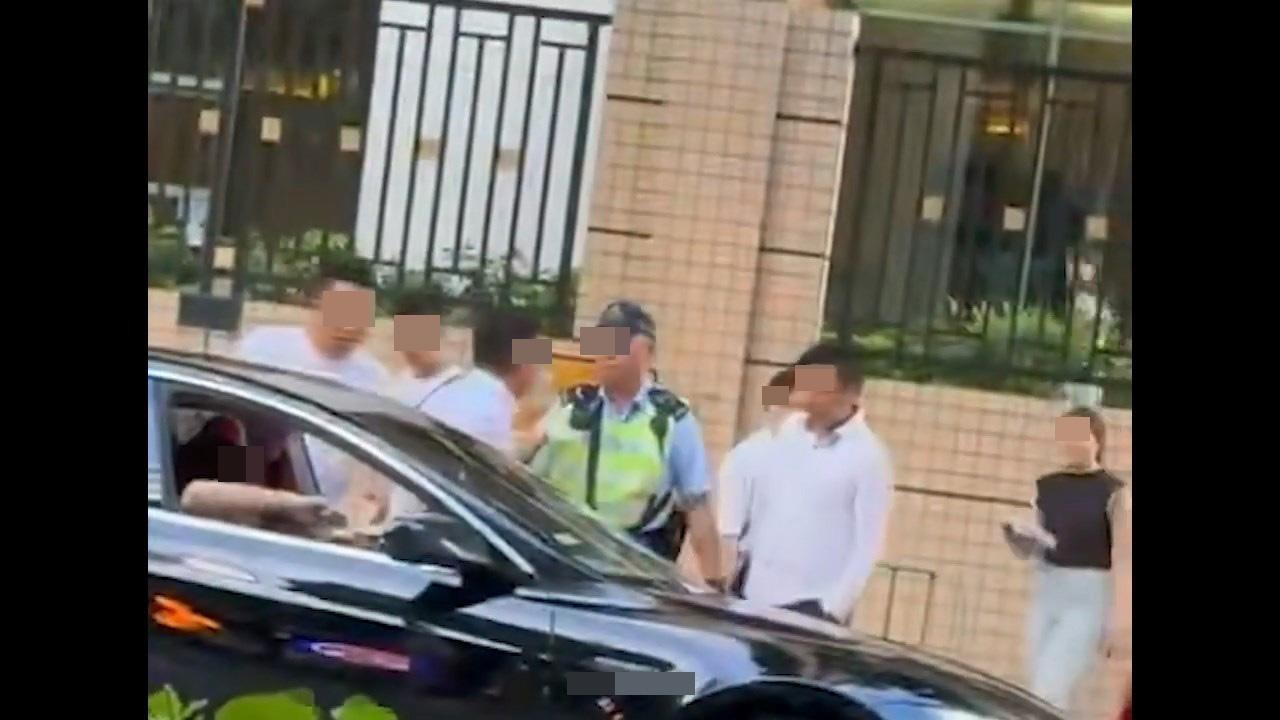 本港網絡流傳1段影片，見到有TESLA私家車違泊雙黃線，1名交通警完上前「抄牌」結果被人包圍。（影片截圖）
