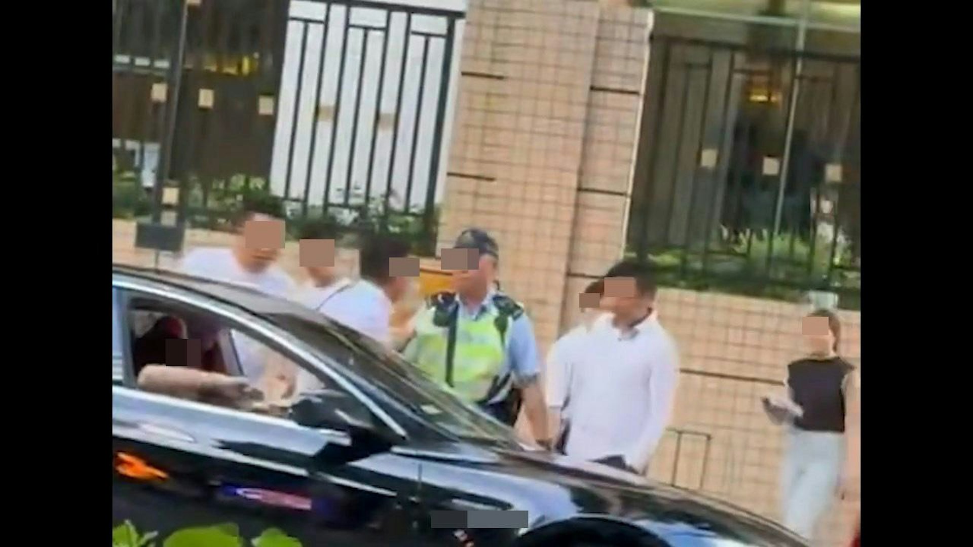 本港網絡流傳1段影片,見到有TESLA私家車違泊雙黃線,1名交通警完上前「抄牌」結果被人包圍。(影片截圖)