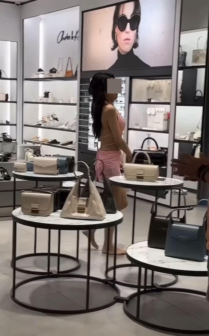影片见到，该女游客穿着性感，赤脚在店内游走，扫落货架上多件商品，与职员争执，更走出店外向围观人群咆哮。（影片截图）