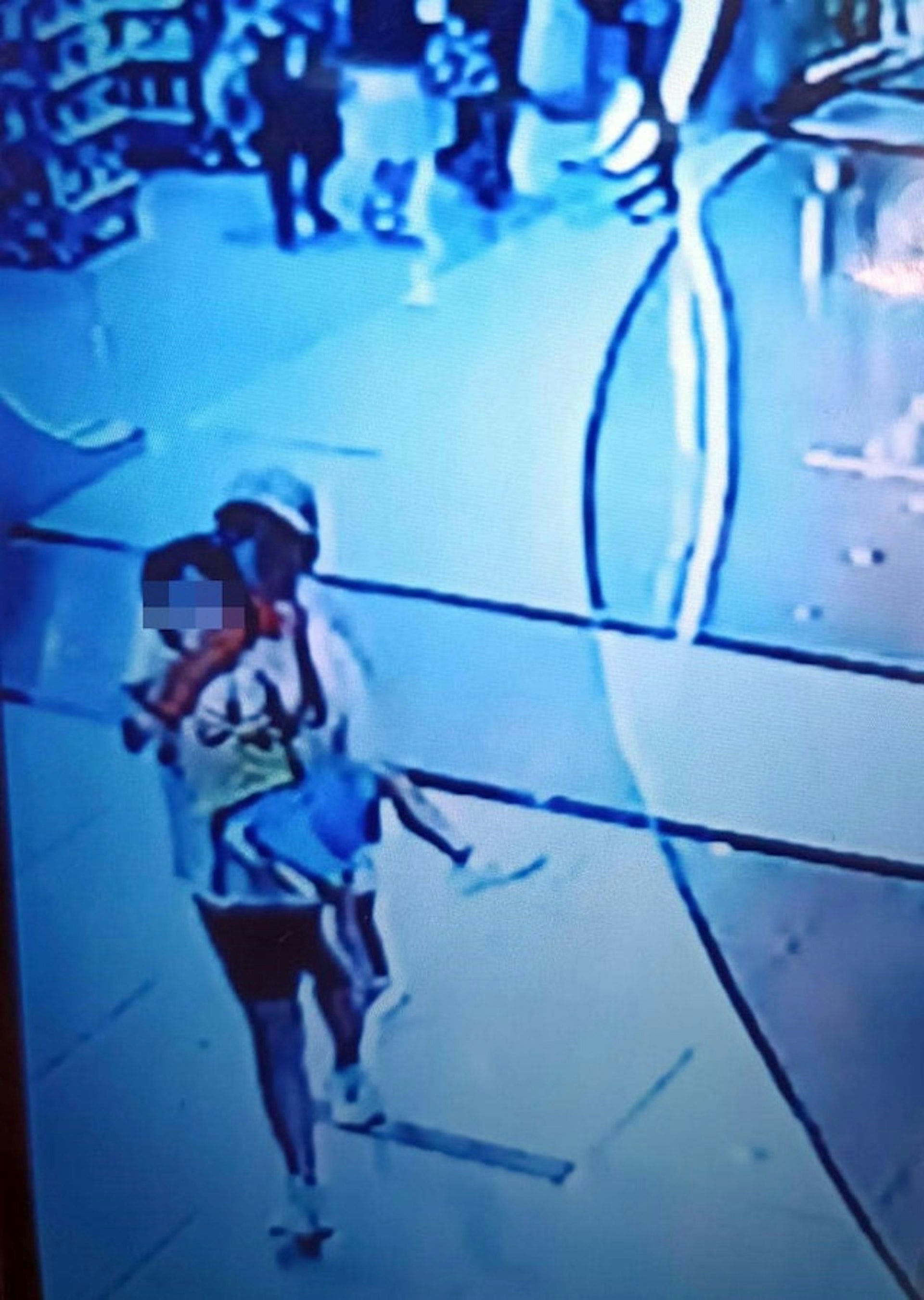 網上廣傳一張閉路電視照片,可見有人用手巾掩住兒童的嘴後抱走。(網上圖片) 網上廣傳一張閉路電視照片,可見有人用手巾掩住兒童的嘴後抱走。(網上圖片)