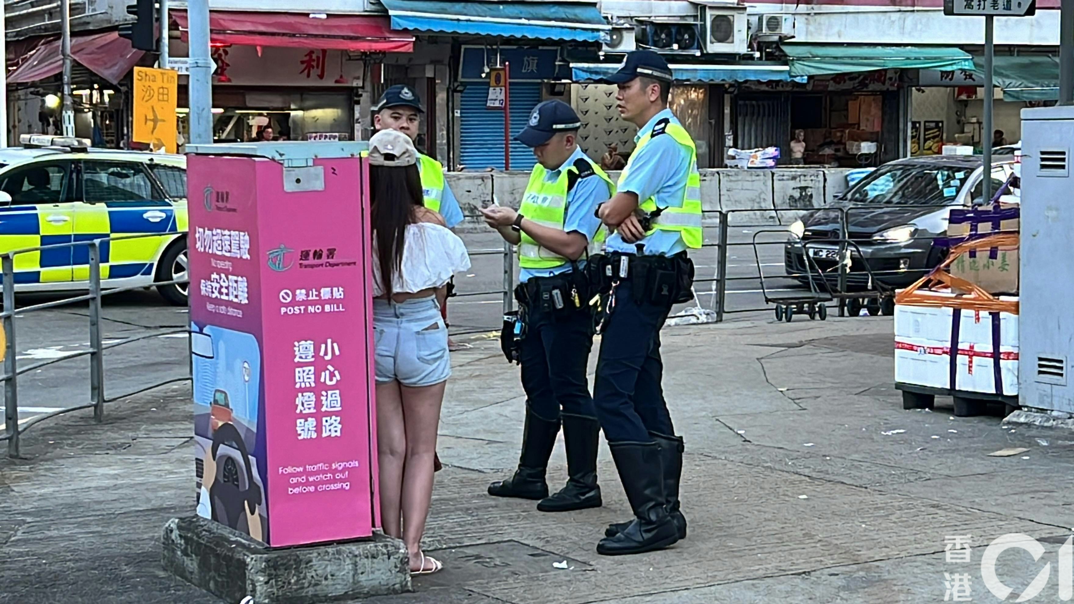 涉事女乘客戴帽和身穿短褲，在場協助警員調查。（李家傑攝）