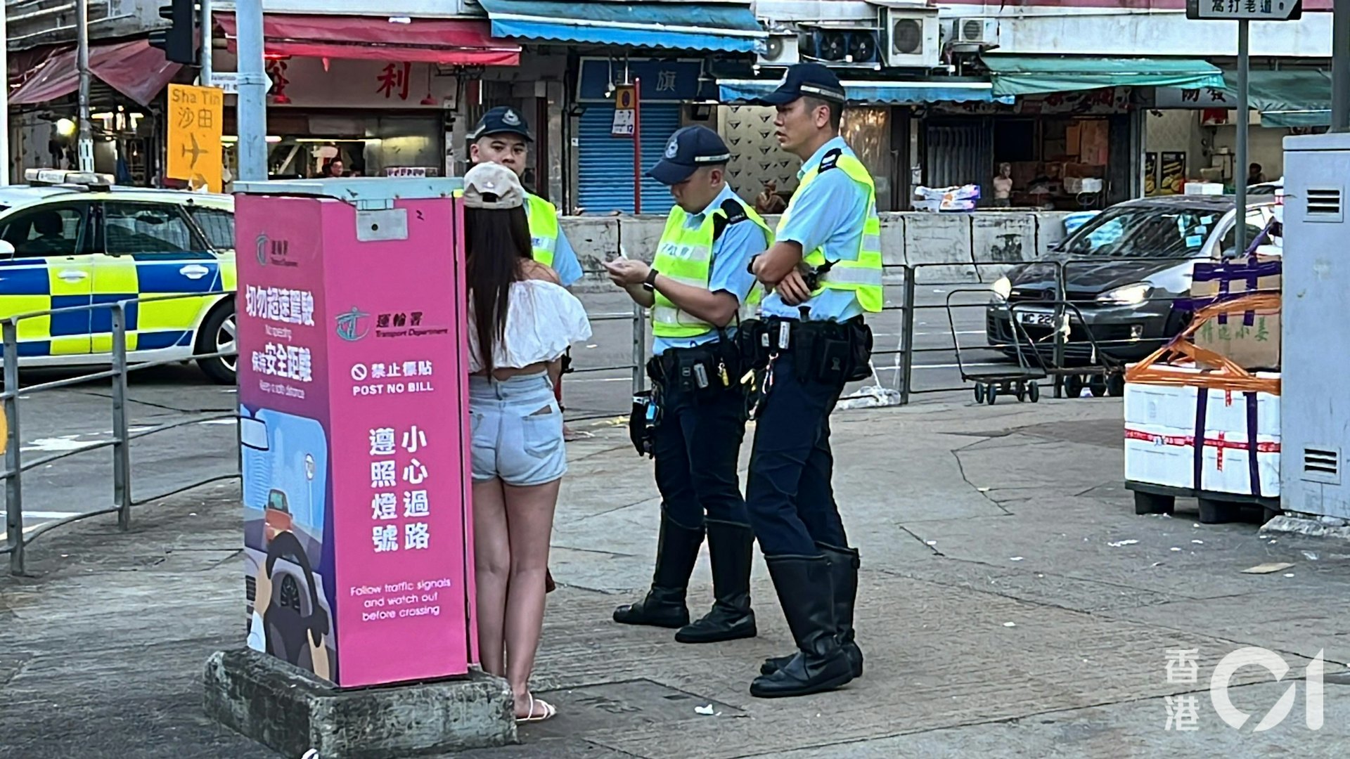 涉事女乘客戴帽和身穿短褲,在場協助警員調查。(李家傑攝)
