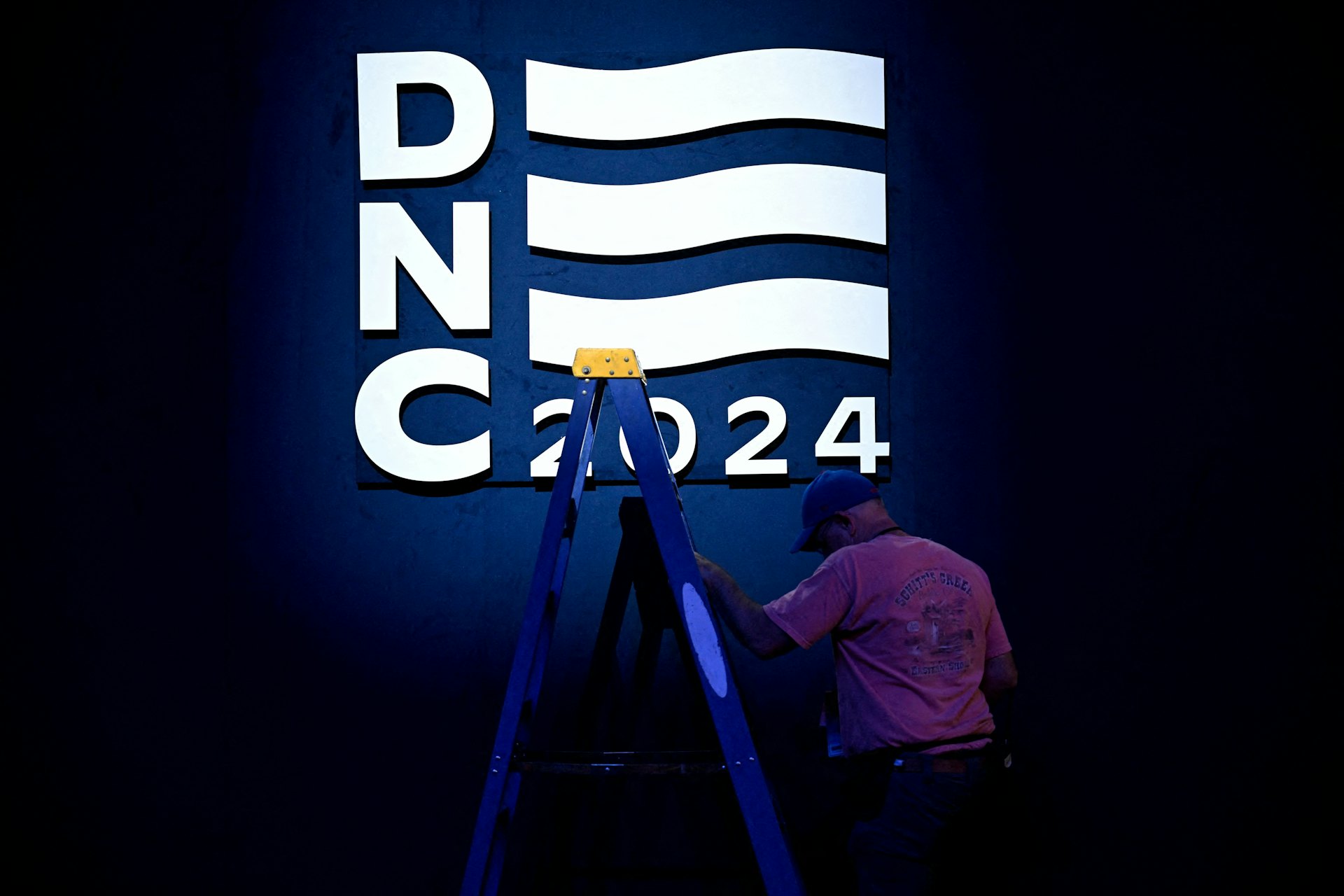 2024年8月18日,一名工人在美國芝加哥民主黨全國代表大會(DNC)舉辦地的DNC標誌旁舉著梯子。(Reuters) 2024年8月18日,一名工人在美國芝加哥民主黨全國代表大會(DNC)舉辦地的DNC標誌旁舉著梯子。(Reuters)