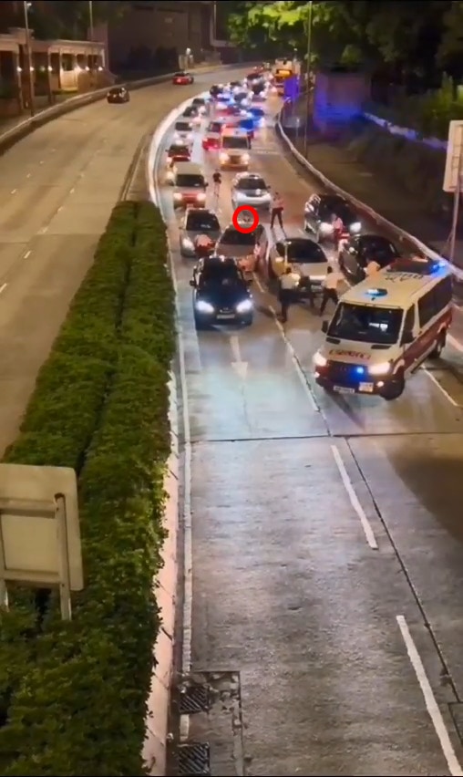 銀色車倒後，一名當時在車尾位置的男警（紅圈示）被「撞到正」倒地。（網上片段截圖）