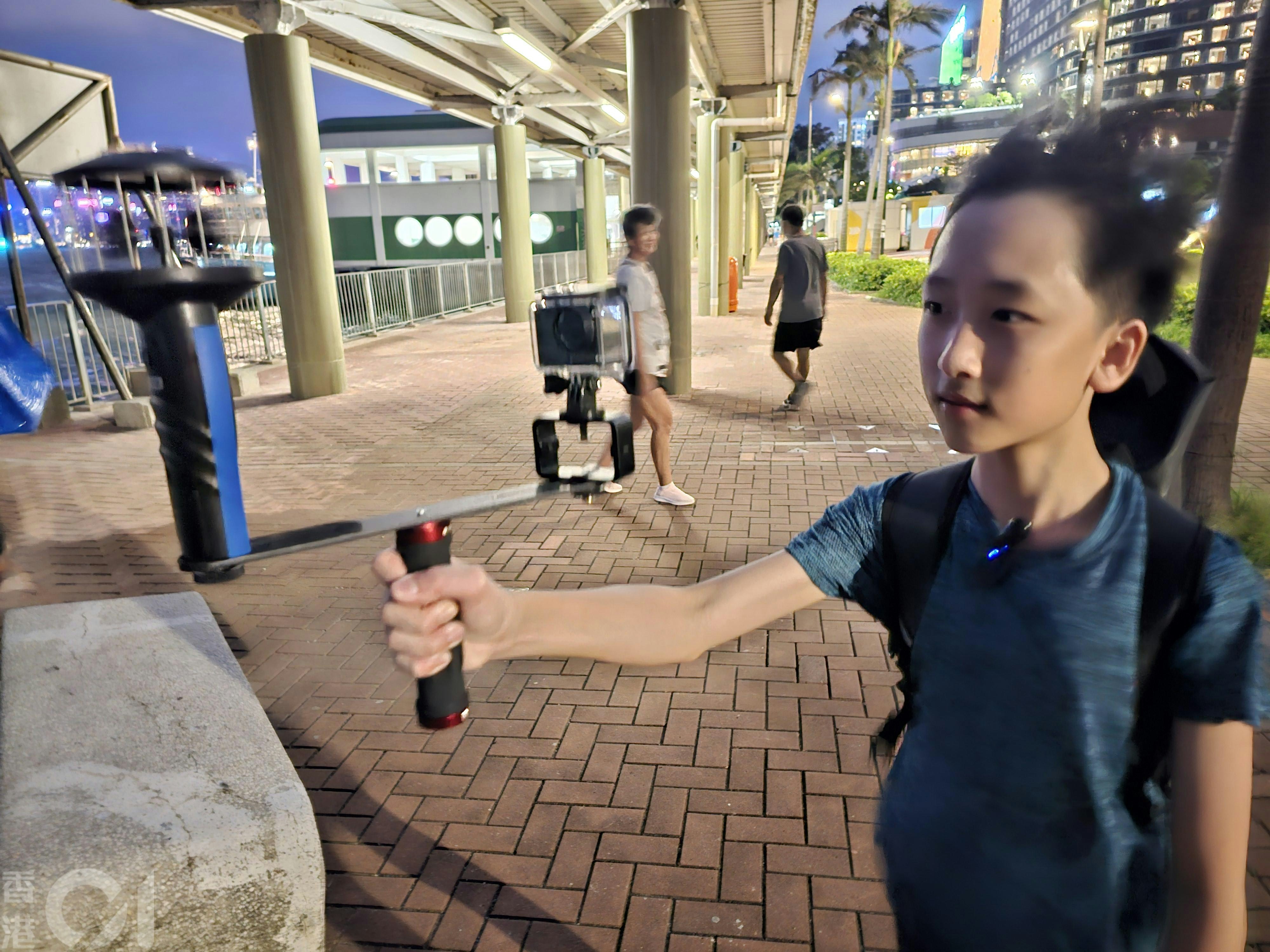 8號風球下，不少市民在紅磡碼頭追風。就讀中二的Hugo在祖母陪同下，手持測風儀、GoPro等設備紀錄颱風風速。(梁偉權攝）