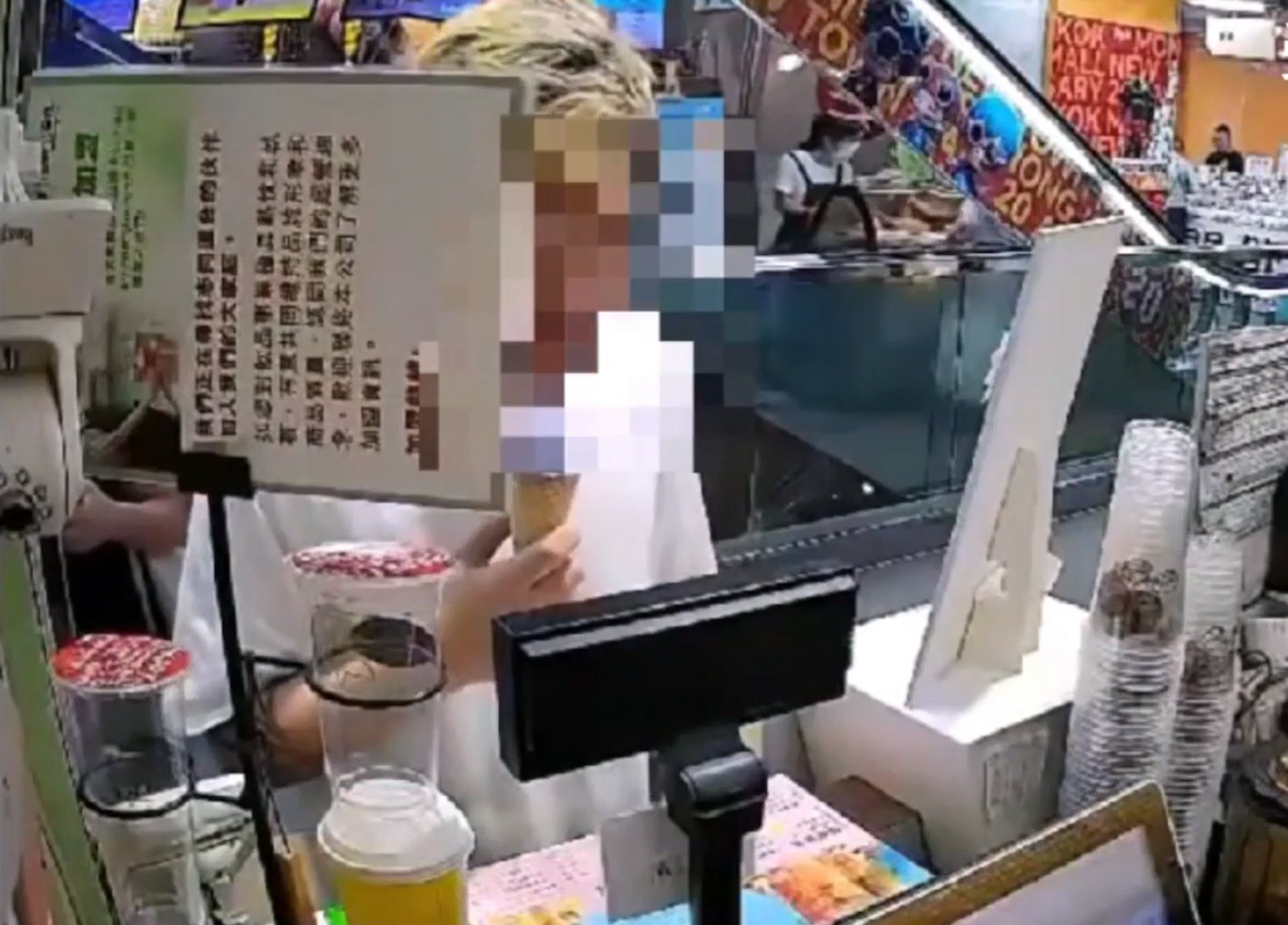 金毛紋身男昨晚(7日)食住雪糕,十分自然地到飲品店用假鈔購買飲品。(受訪者提供影片截圖)