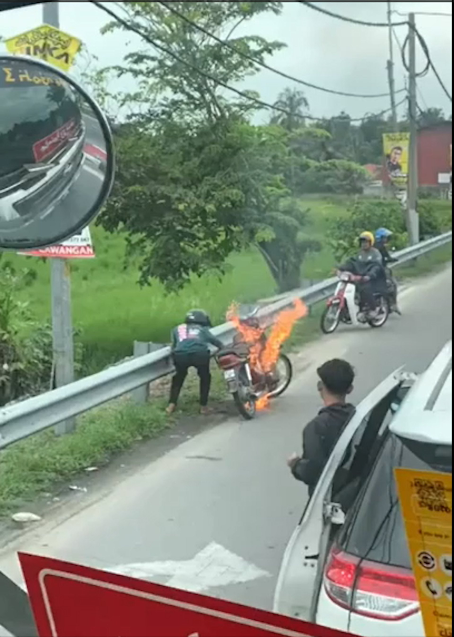馬來西亞有電單車於公路突然起火,鐵騎士脫下拖鞋撲火。(YouTube影片截圖) 馬來西亞有電單車於公路突然起火,鐵騎士脫下拖鞋撲火。(YouTube影片截圖)