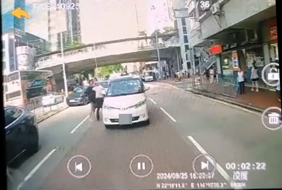 黑衫男回身用手掩面,並連環揮拳毆打老翁頭部,令老翁失平衝向後挨在白色七人車上。 黑衫男回身用手掩面,並連環揮拳毆打老翁頭部,令老翁失平衝向後挨在白色七人車上。