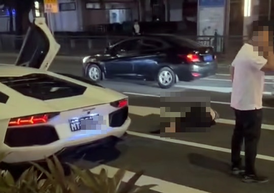 涉事白色林寶堅尼停在現場，相信是司機的男子落車打電話，事主則倒在地上昏迷。(網上圖片)