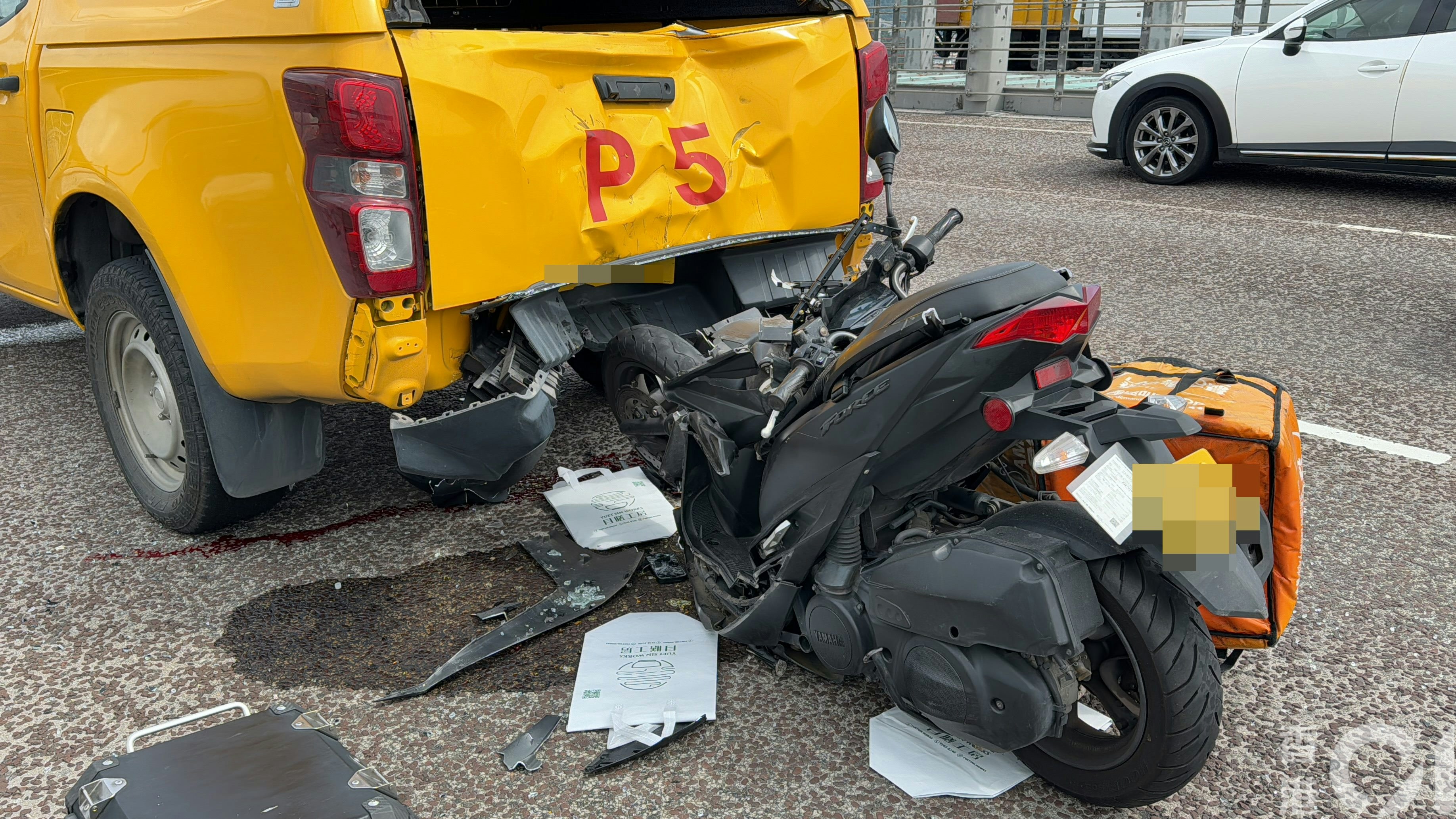 巡邏車車尾凹陷，相信是由電單車運送的袋子散落地面。（蔡正邦攝）