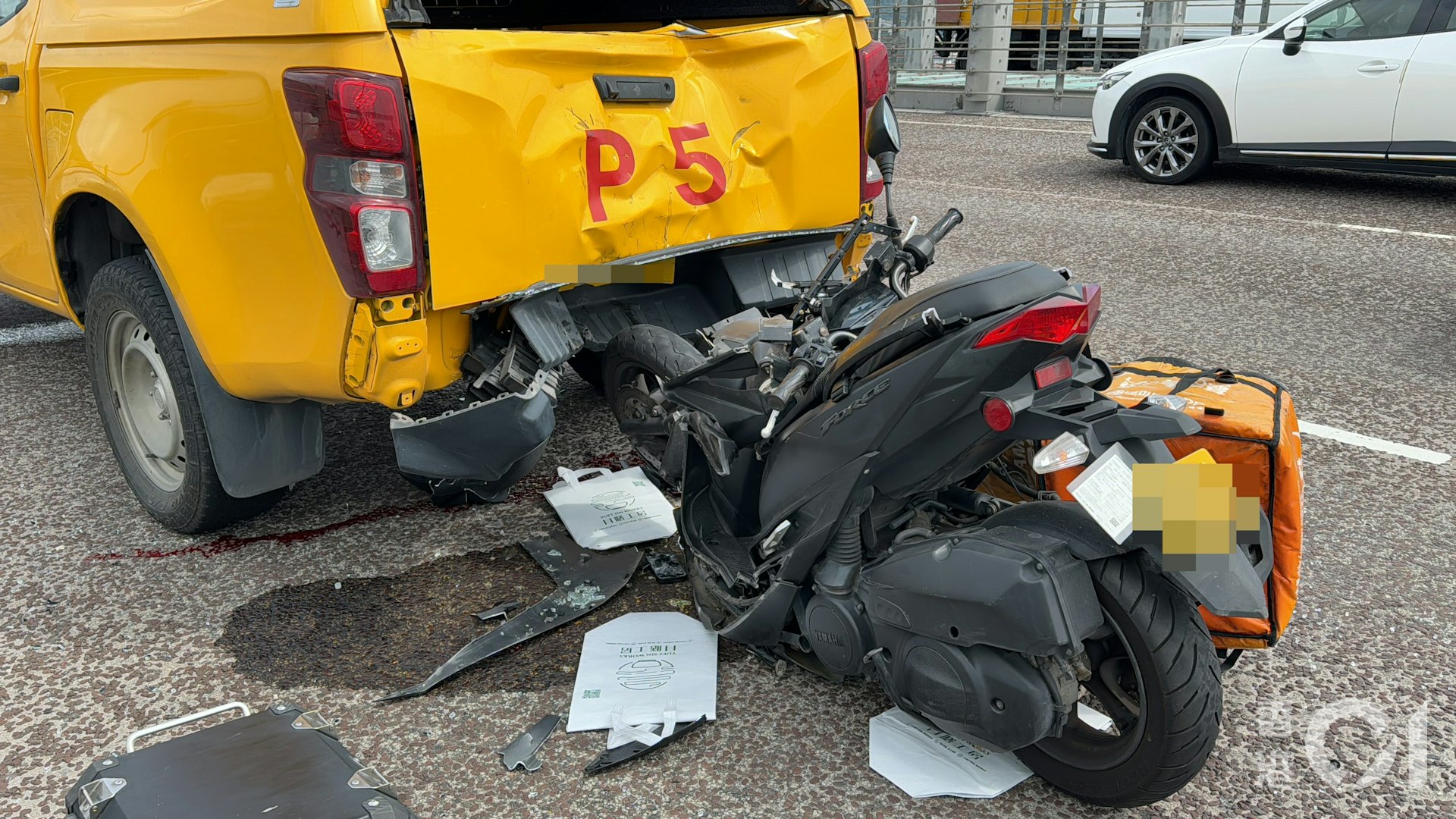 巡邏車車尾凹陷,相信是由電單車運送的袋子散落地面。(蔡正邦攝)