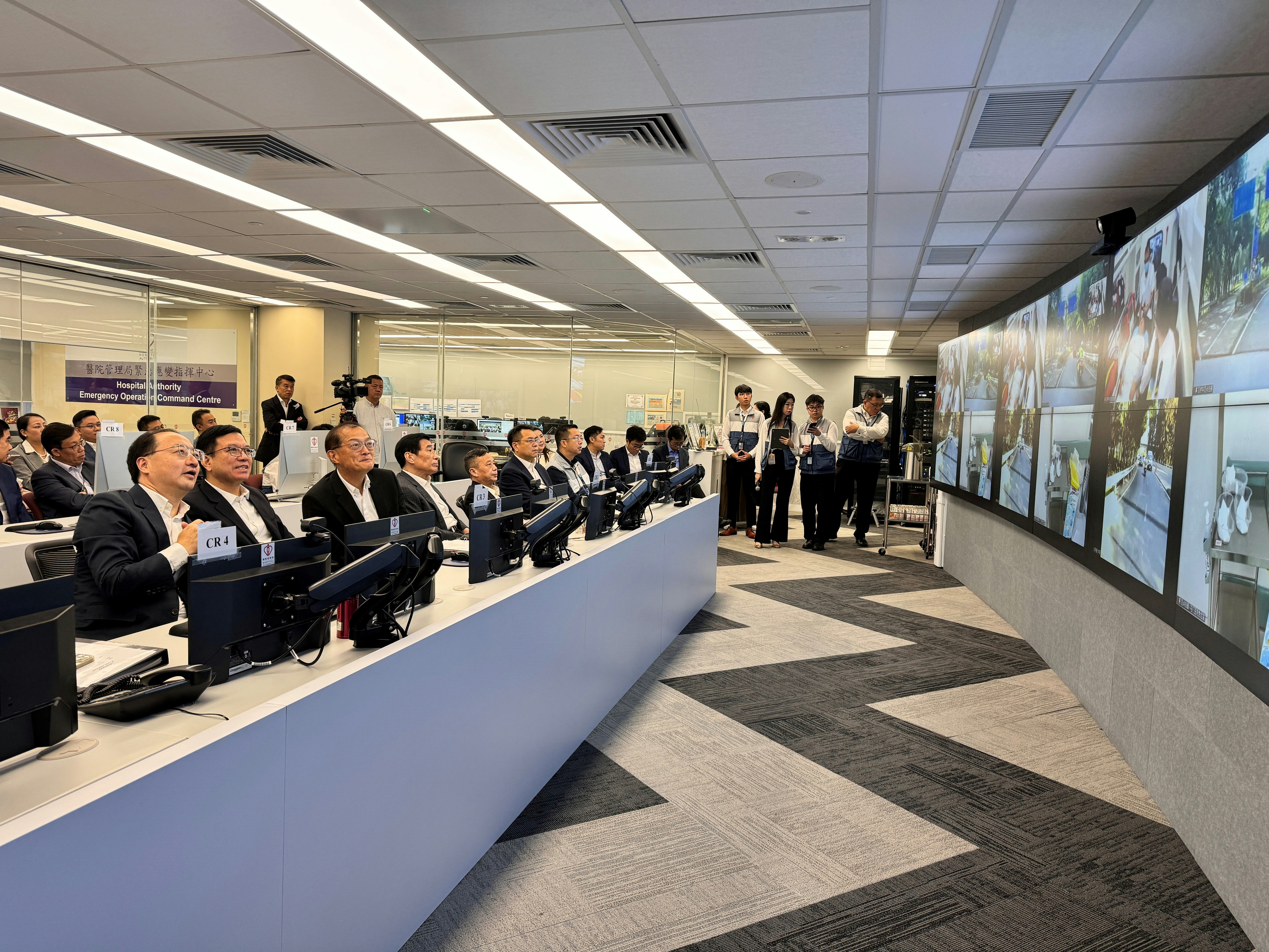 2024年10月31日，港府聯同廣東省和深圳市政府進行第二次「大灣區跨境直通救護車試行計劃」演練。圖為醫務衞生局局長盧寵茂（左三）、廣東省港澳事務辦公室副主任張志華（左一）、廣東省衞生健康委員會副主任鄧林峰（左二），和醫管局主席范鴻齡（左四）在醫管局重大事故控制中心視察演練情況。（政府新聞處圖片）