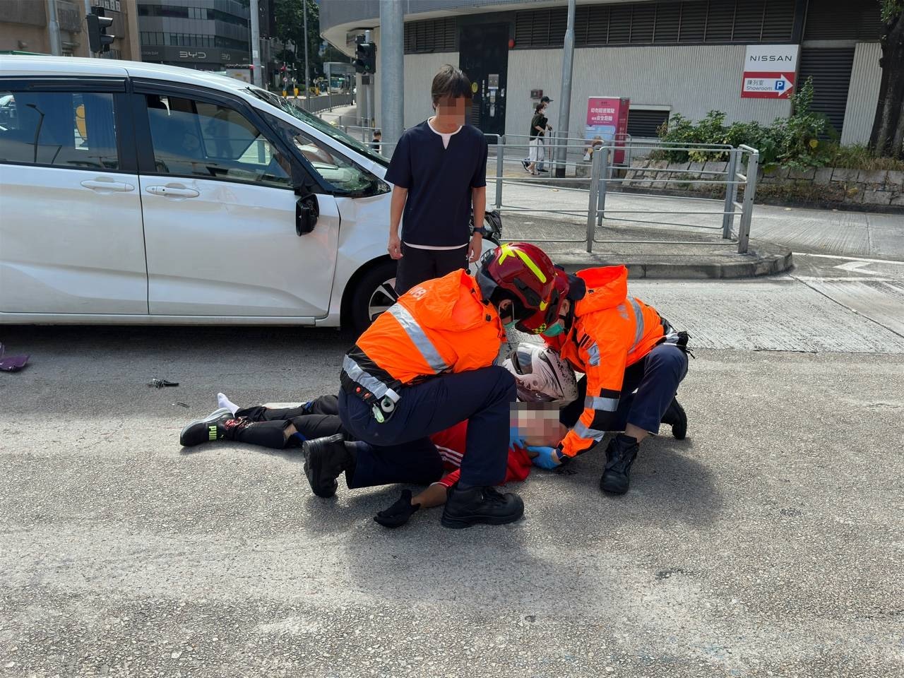 七人車司機望住救護員替鐵騎士急救。（翁鈺輝攝）