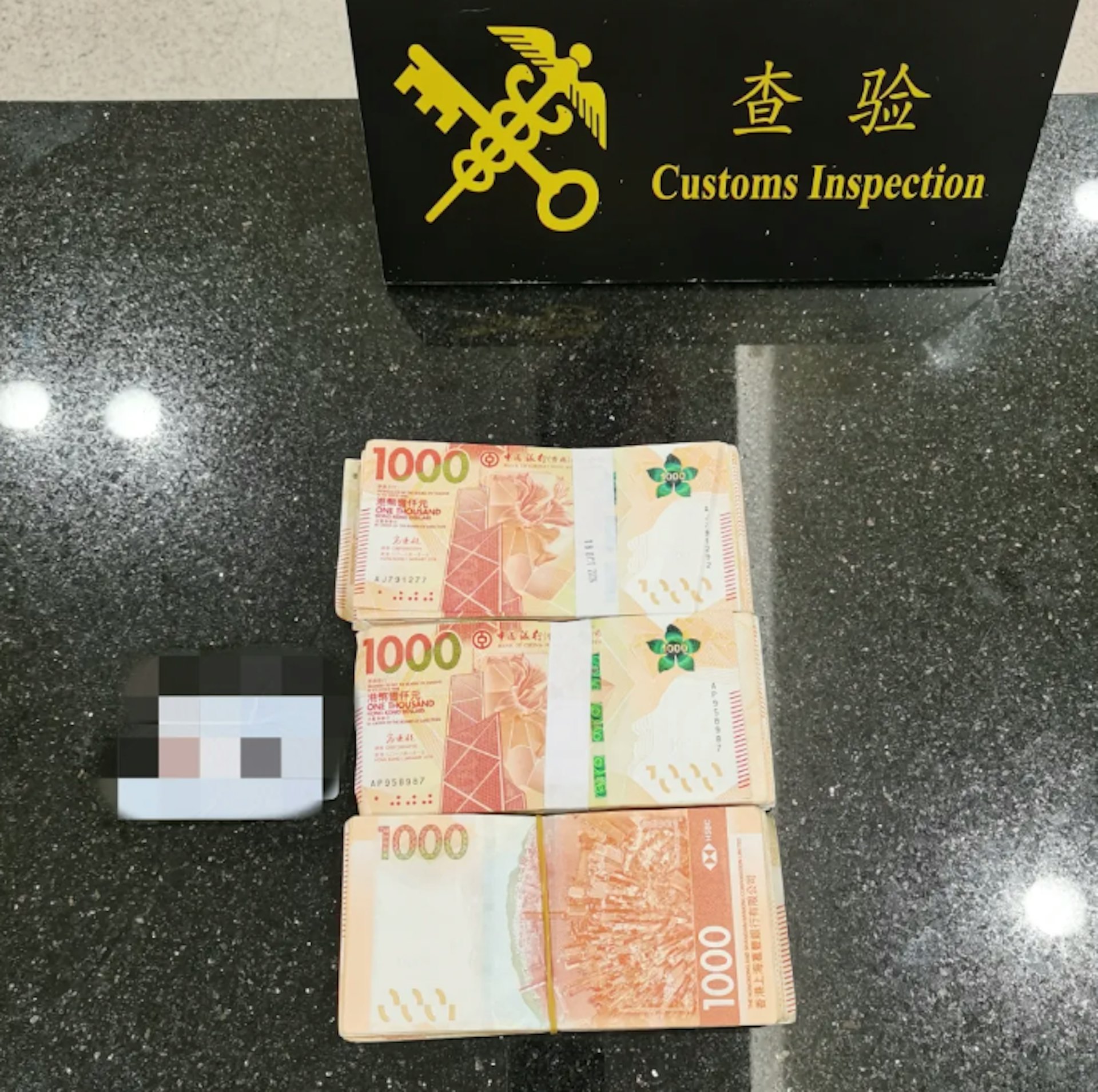 一名旅客經青茂口岸旅檢現場「無申報通道」出境(即由珠海進入澳門),海關關員在該旅客口袋中發現未申報的港幣共30萬元。(中國海關總署)