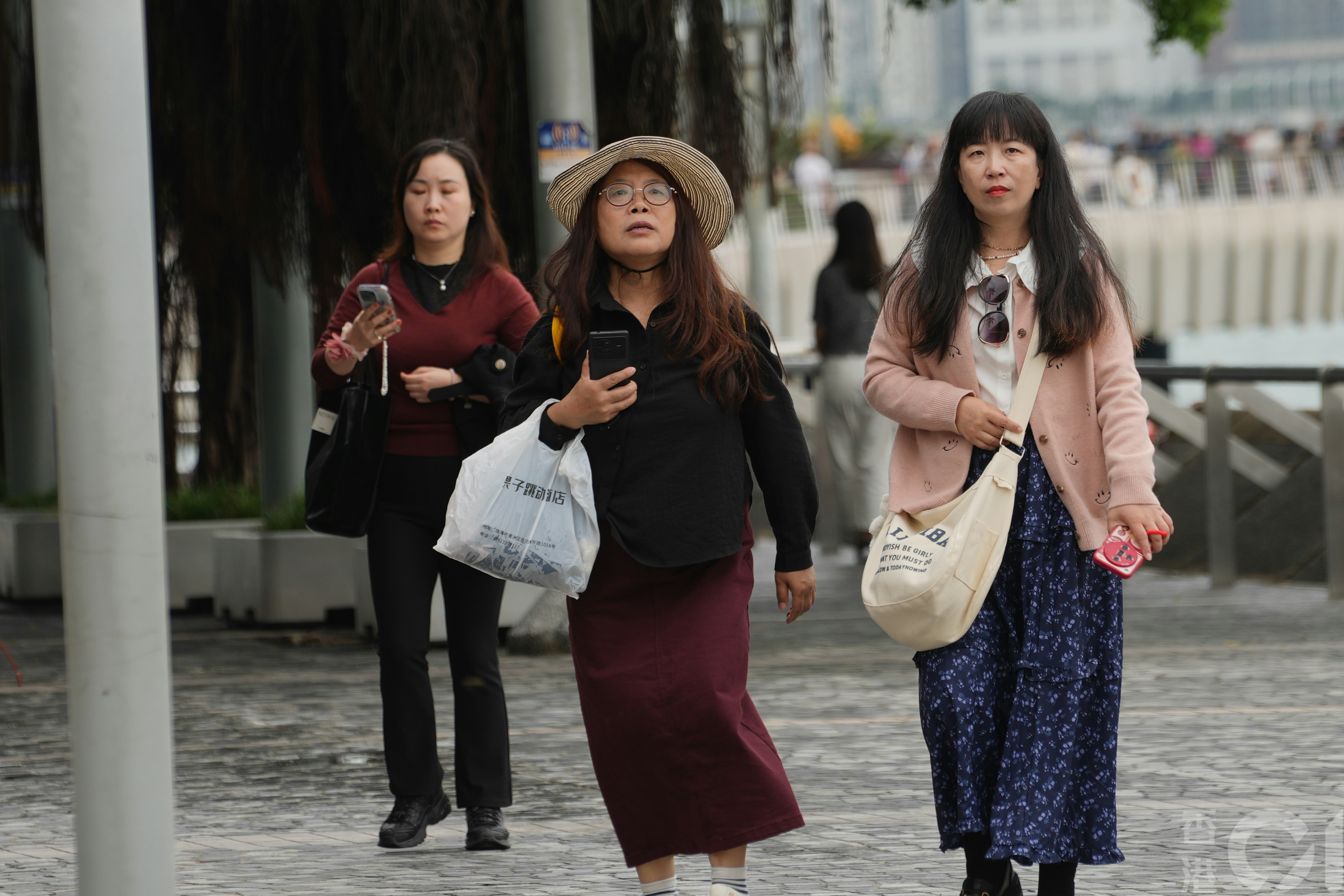 11月21日天陰，間中有雨粉，在尖沙咀海旁，氣溫中午約攝氏20度，有市民及遊客加添外套，也有人穿短袖衣服。（黃浩謙攝）