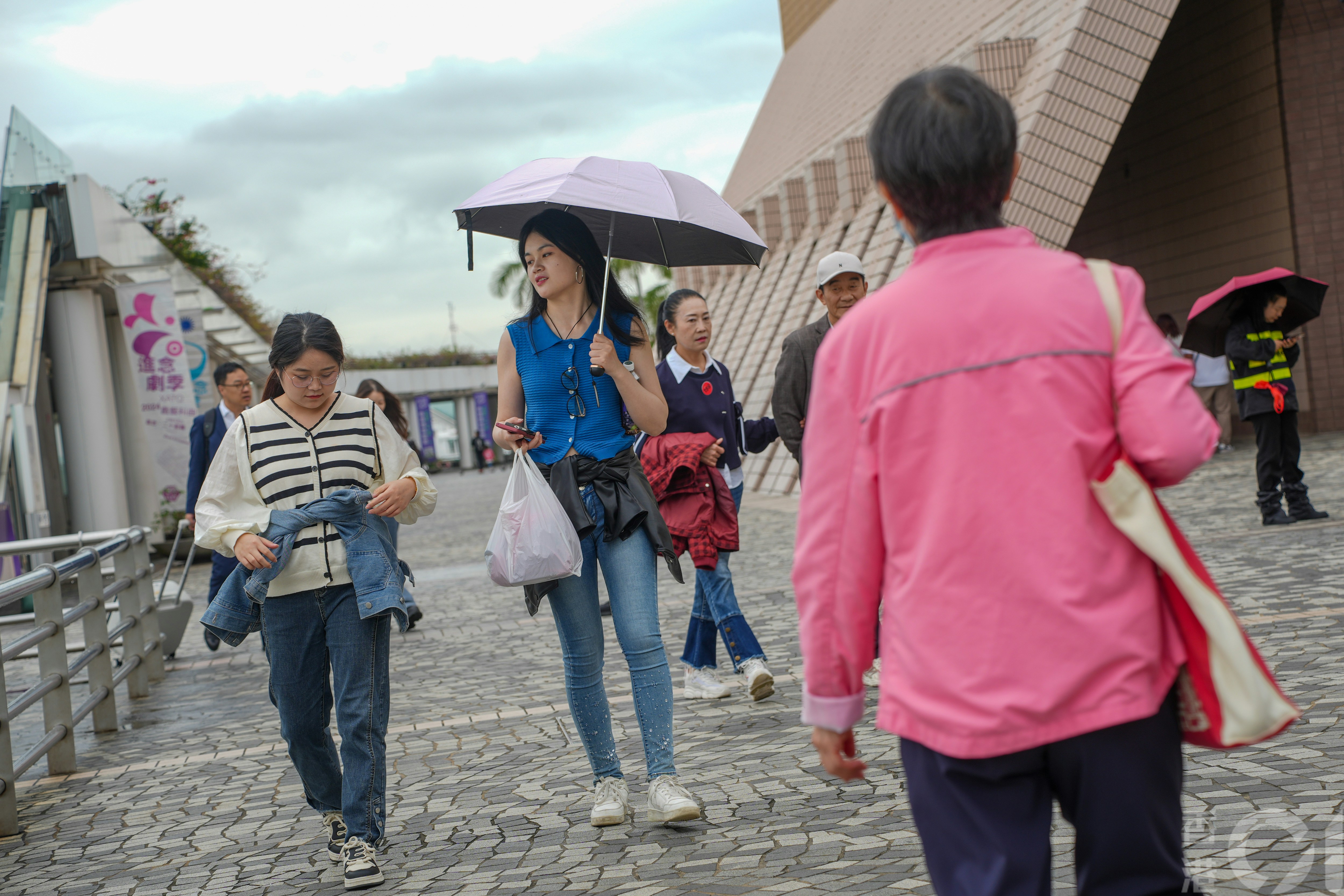 11月21日天陰，間中有雨粉，在尖沙咀海旁，氣溫中午約攝氏20度，有市民及遊客加添外套，也有人穿短袖衣服。（黃浩謙攝）