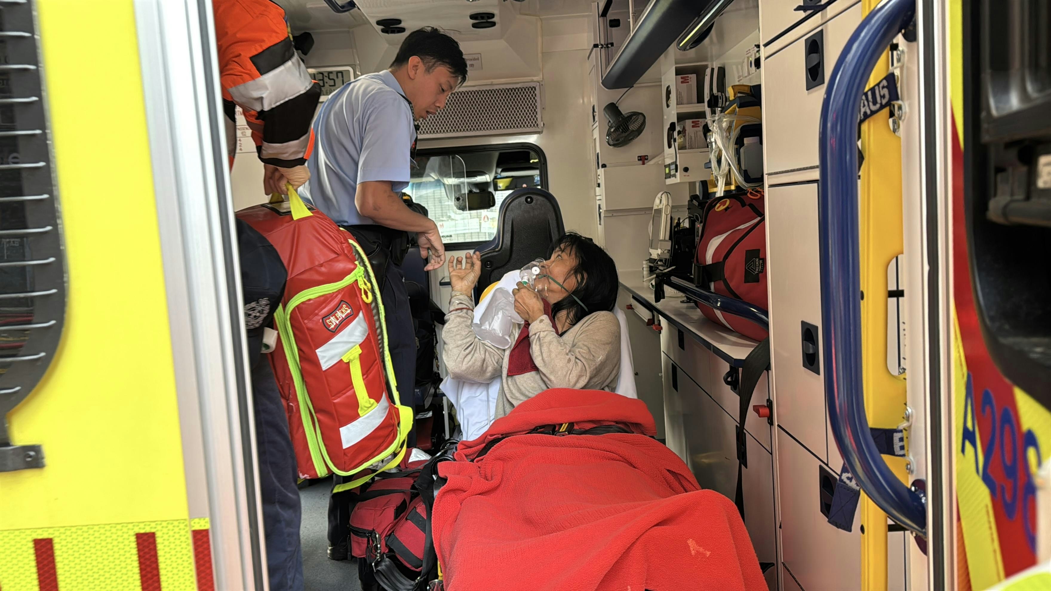 其中一名女子登上救護車，其後送到廣華醫院治理。（翁鈺輝攝）