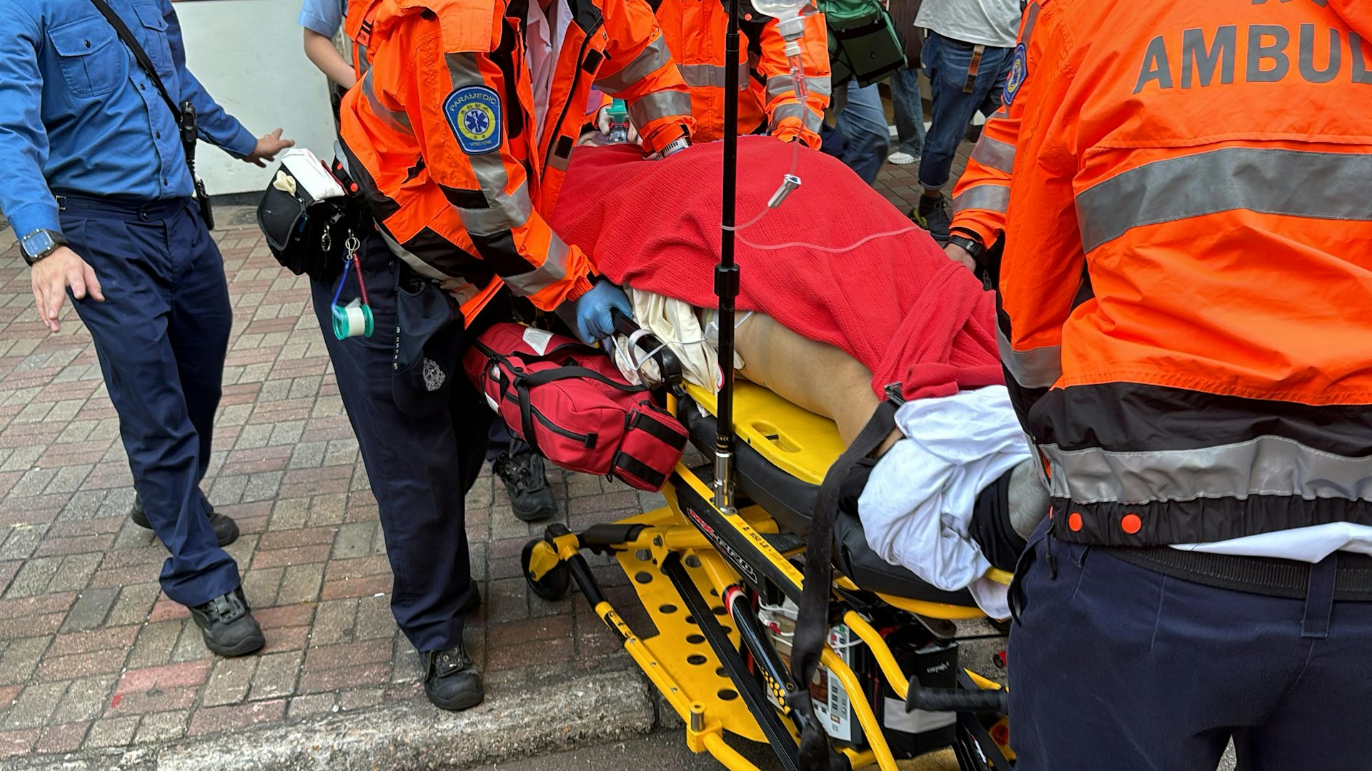 中環歐陸貿易中心一名男工人維修扶手電梯時跌入坑槽被困,逾一小時後被救出,昏迷送院搶救,送院時救護員不停為事主進行心外壓。(陳浩然攝) 中環歐陸貿易中心一名男工人維修扶手電梯時跌入坑槽被困,逾一小時後被救出,昏迷送院搶救,送院時救護員不停為事主進行心外壓。(陳浩然攝)