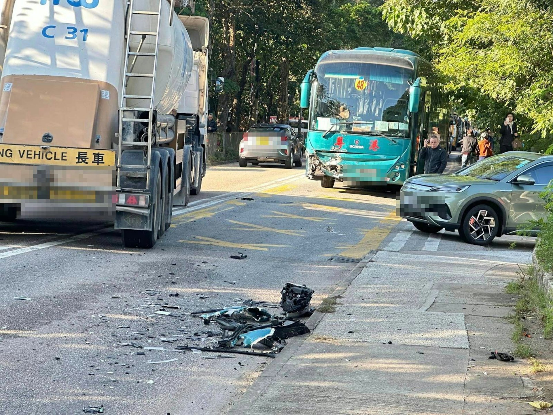 旅遊巴車頭損毀,路面有碎片。(Facebook「粉嶺皇后山關注組」圖片) 旅遊巴車頭損毀,路面有碎片。(Facebook「粉嶺皇后山關注組」圖片)