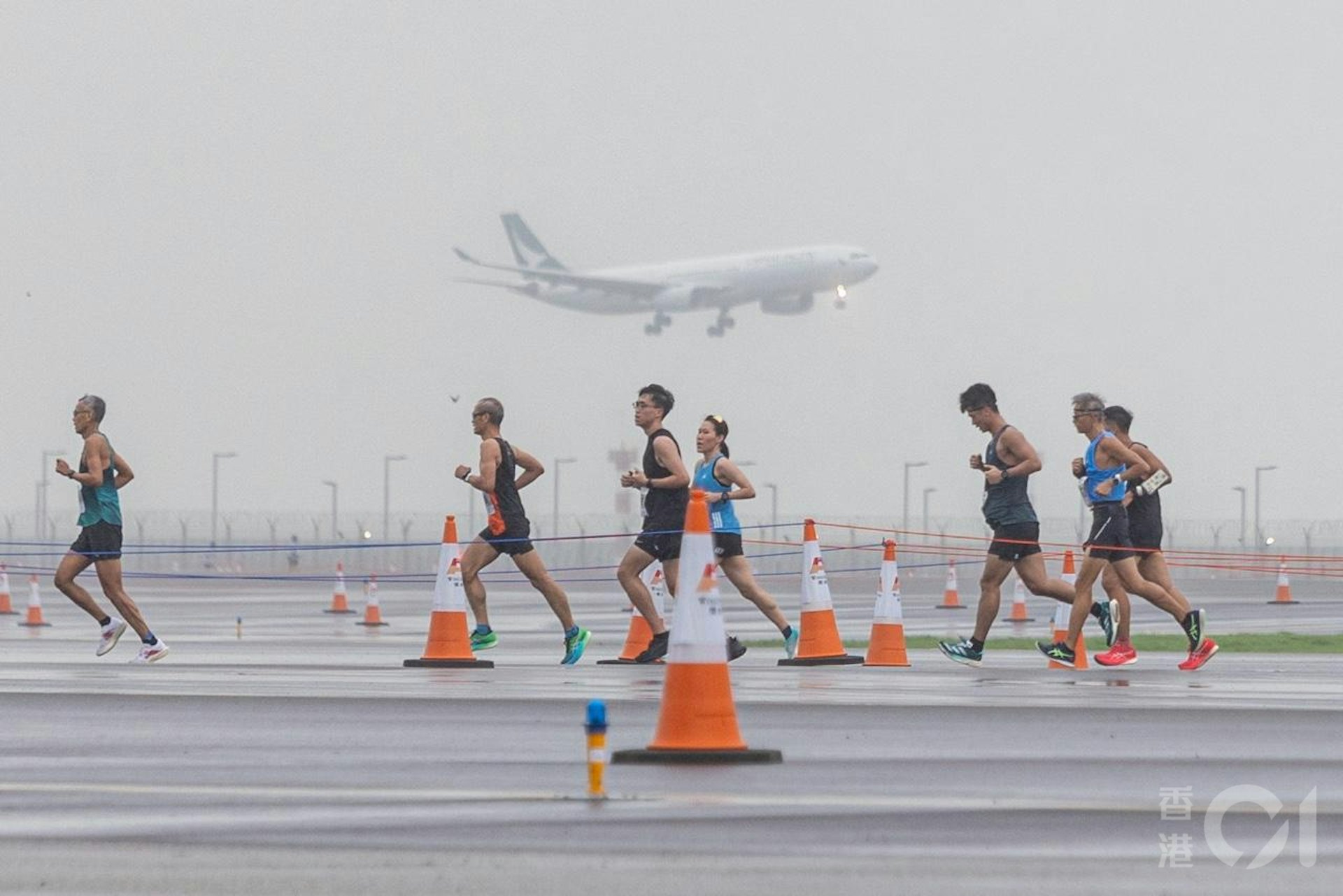 機管局在11月17日在趁機場中跑道未啟用前,舉行「渣打香港馬拉松:三跑道系統十公里國際賽」,是機場繼1998年後再次上演長跑賽,期間有飛機在北跑道如常降落。(梁鵬威攝) 機管局在11月17日在趁機場中跑道未啟用前,舉行「渣打香港馬拉松:三跑道系統十公里國際賽」,是機場繼1998年後再次上演長跑賽,期間有飛機在北跑道如常降落。(梁鵬威攝)