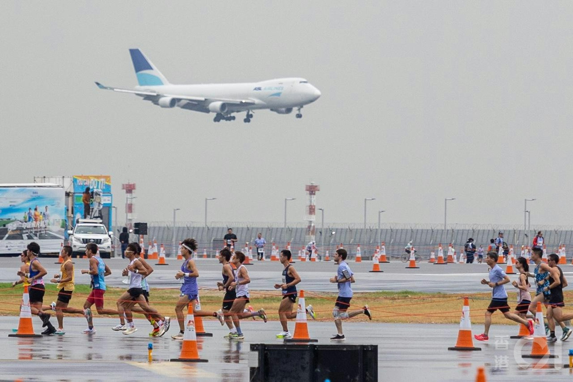 機管局在11月17日在趁機場中跑道未啟用前,舉行「渣打香港馬拉松:三跑道系統十公里國際賽」,是機場繼1998年後再次上演長跑賽,期間有飛機在北跑道如常降落。(梁鵬威攝) 機管局在11月17日在趁機場中跑道未啟用前,舉行「渣打香港馬拉松:三跑道系統十公里國際賽」,是機場繼1998年後再次上演長跑賽,期間有飛機在北跑道如常降落。(梁鵬威攝)
