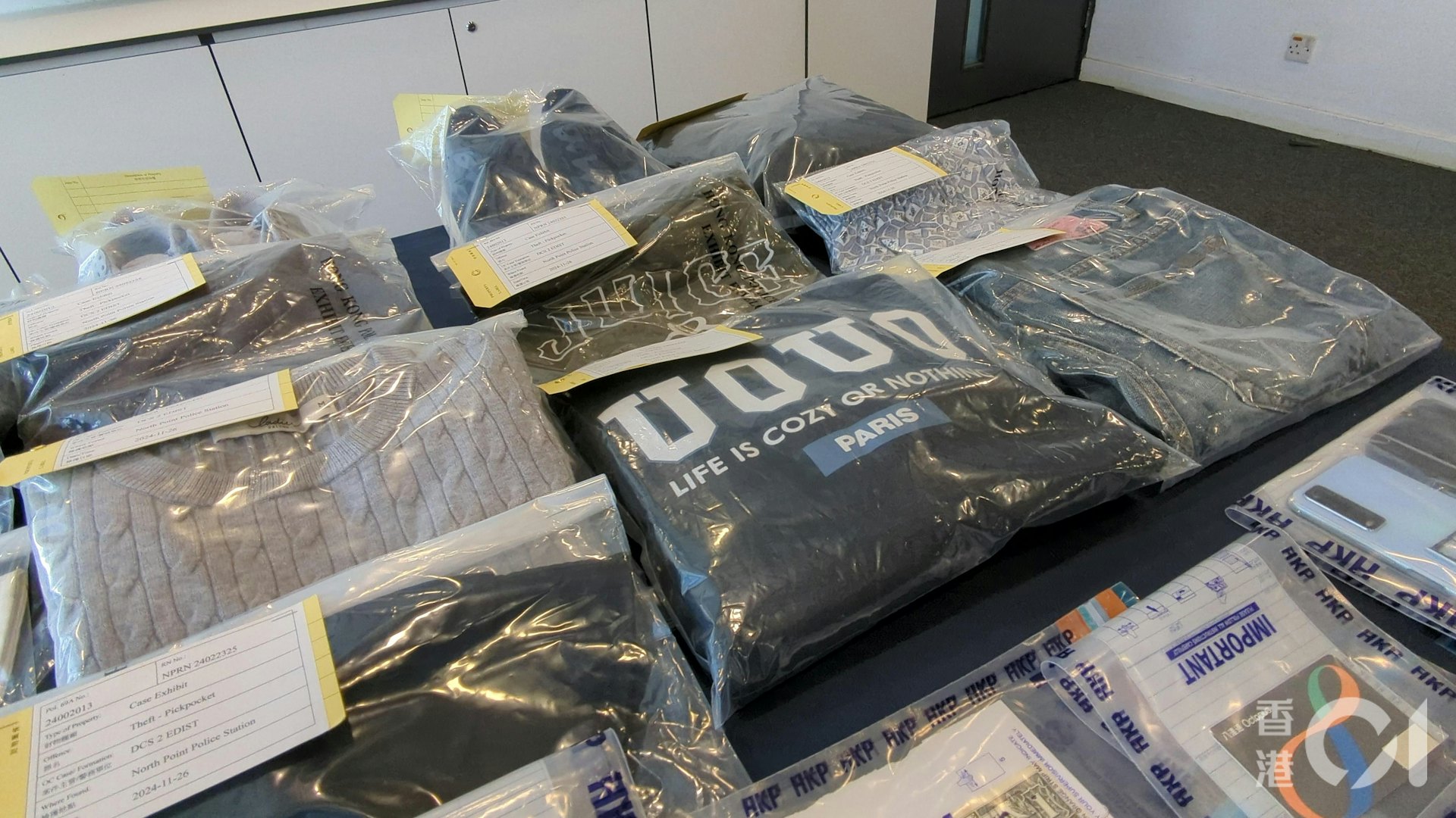 警方檢獲一批證物,包括鈔票和衣物。(黃偉民攝) 警方檢獲一批證物,包括鈔票和衣物。(黃偉民攝)