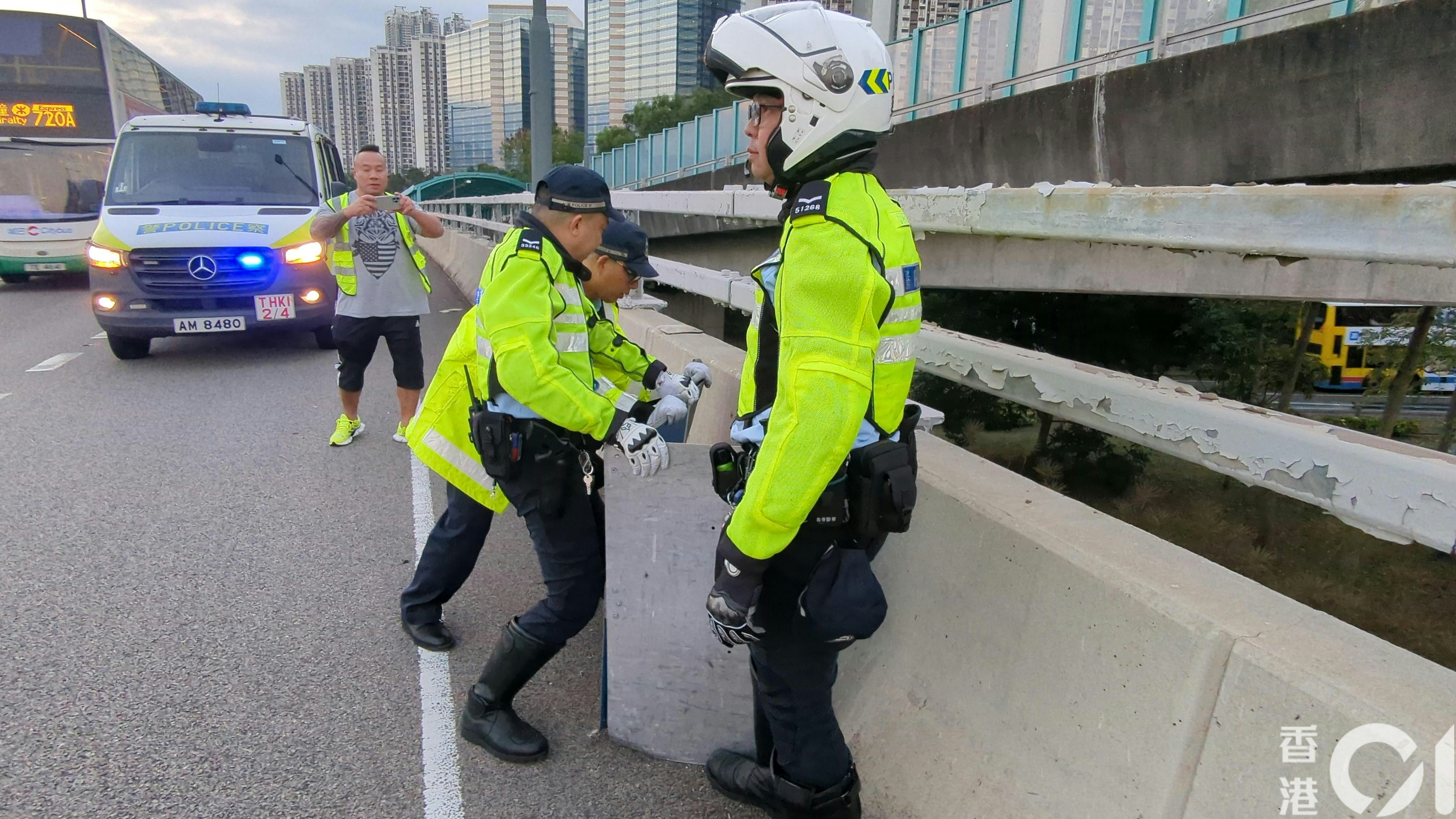 警員用路障路牌將野豬圍到馬路邊。（黃偉民攝）