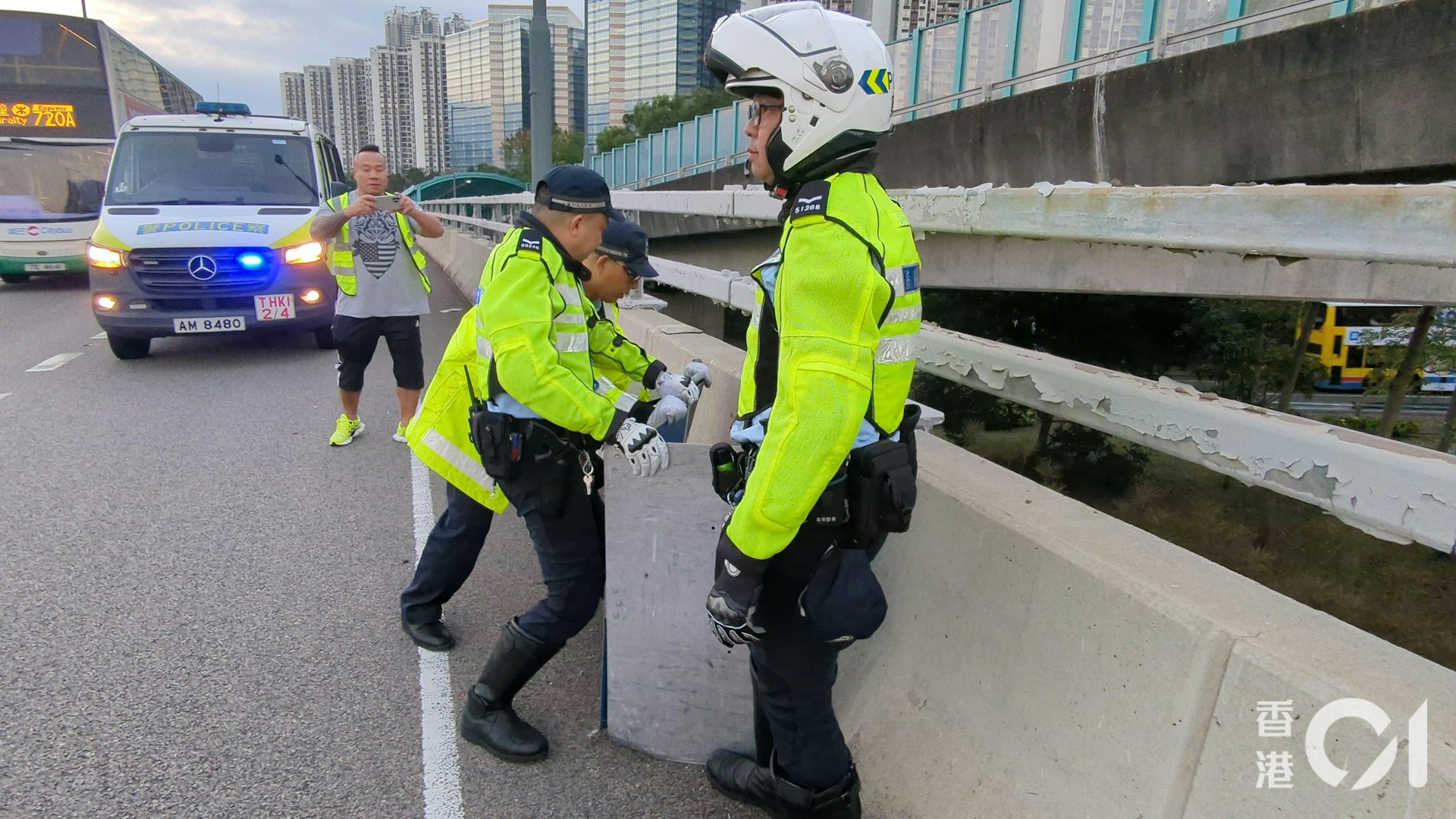 警員用路障路牌將野豬圍到馬路邊。(黃偉民攝) 警員用路障路牌將野豬圍到馬路邊。(黃偉民攝)