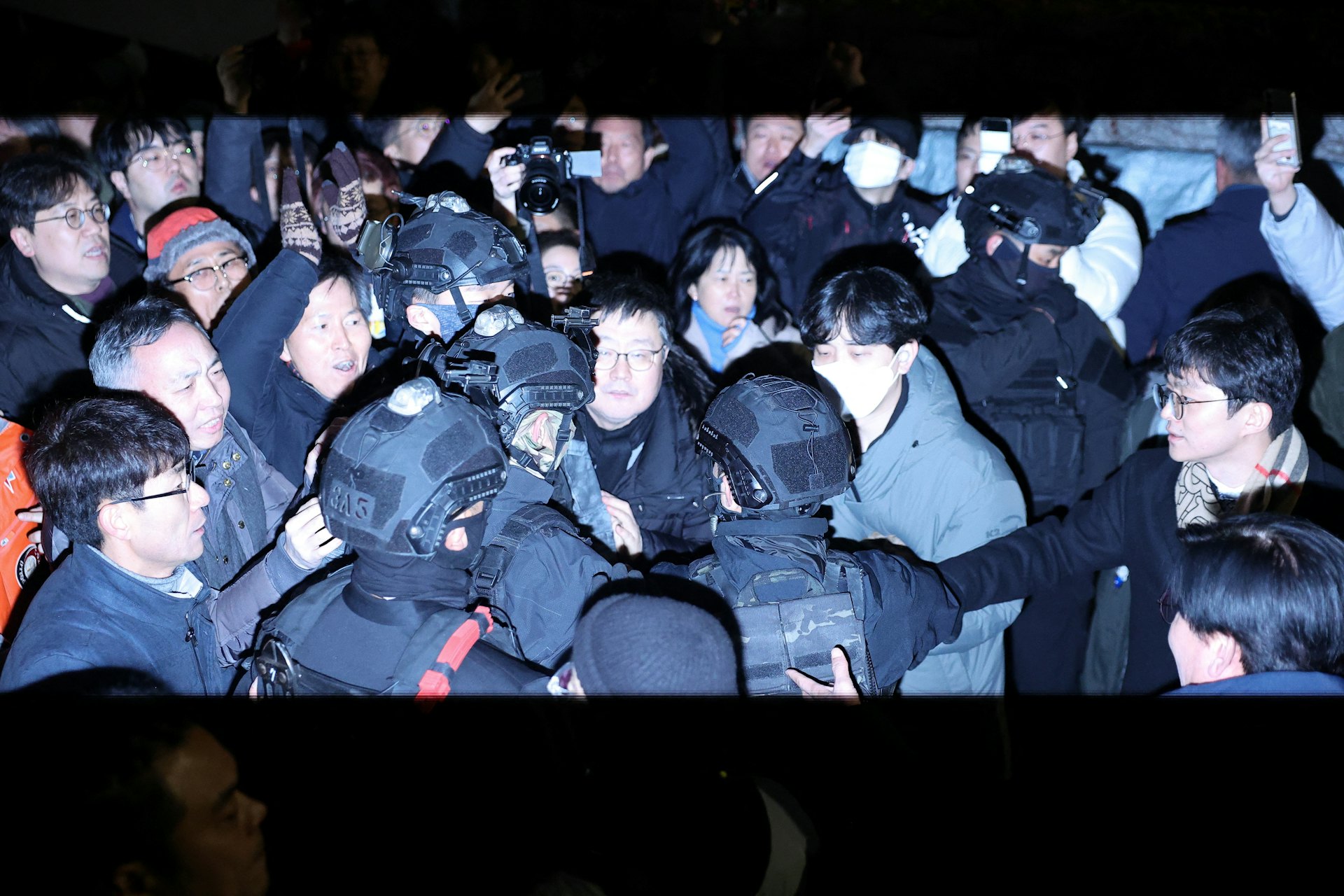 韓國戒嚴|南韓12月3日深夜突宣布實施戒嚴令。軍人穿過國會前的人群。(Reuters路透社圖片) 韓國戒嚴|南韓12月3日深夜突宣布實施戒嚴令。軍人穿過國會前的人群。(Reuters路透社圖片)