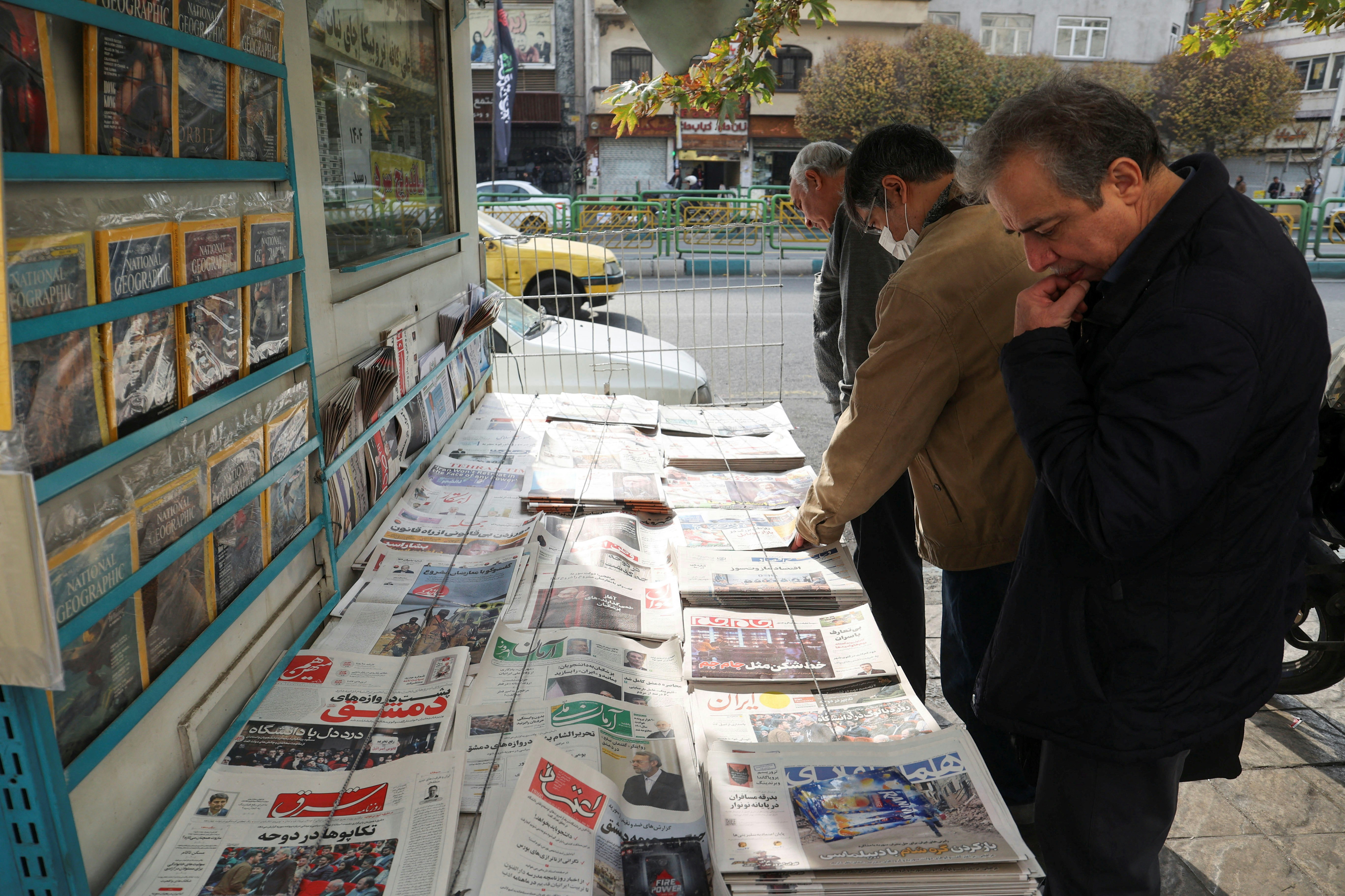 圖為2024年12月8日，伊朗德黑蘭民眾在報攤閱讀報章。（Majid Asgaripour/WANA (West Asia News Agency) via REUTERS）