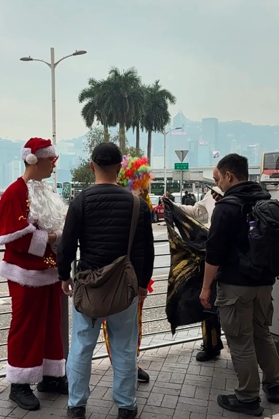 有網民在小紅書發文,指在尖沙咀見到有「聖誕老人」與遊人合照索取費用,有疑似便衣警員到場調查,並將其中3人帶回警署。(小紅書) 有網民在小紅書發文,指在尖沙咀見到有「聖誕老人」與遊人合照索取費用,有疑似便衣警員到場調查,並將其中3人帶回警署。(小紅書)