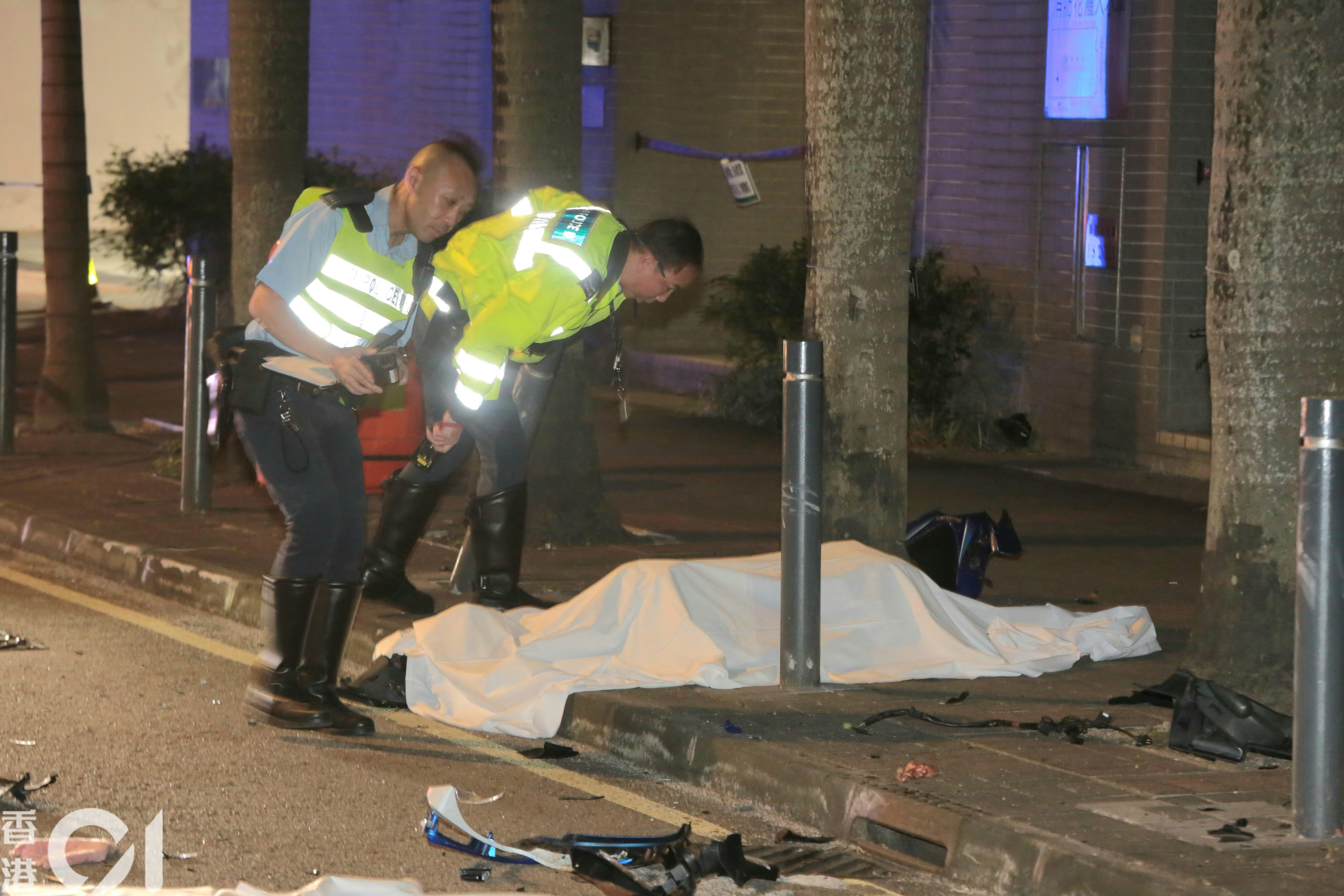 九龍灣宏基街有電單車失事，鐵騎士當場死亡，遺體以白布覆蓋，警員在場調查。（梁偉權攝）