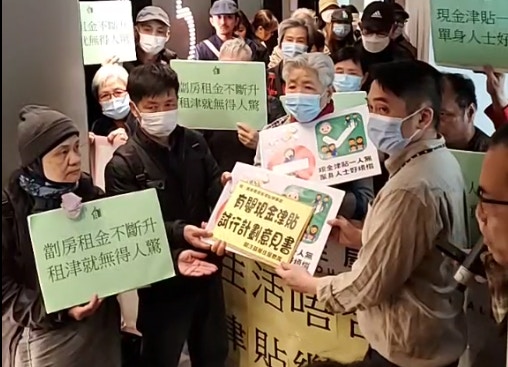 關注基層住屋組織一直向當局爭取，把用以紓緩基層家庭長時間輪候公屋期間時生活困難的現金津貼試行計劃延長甚至恆常化。圖為關注基層住屋聯席早前到位於葵涌的現金津貼辦事處請願。（關注基層住屋聯席Facebook直播截圖）