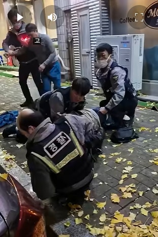 韓國有4名警員在制服2名醉漢，其中1名警員把醉漢按在地上時假時髮突飛脫，影片在網上瘋傳。（影片截圖）