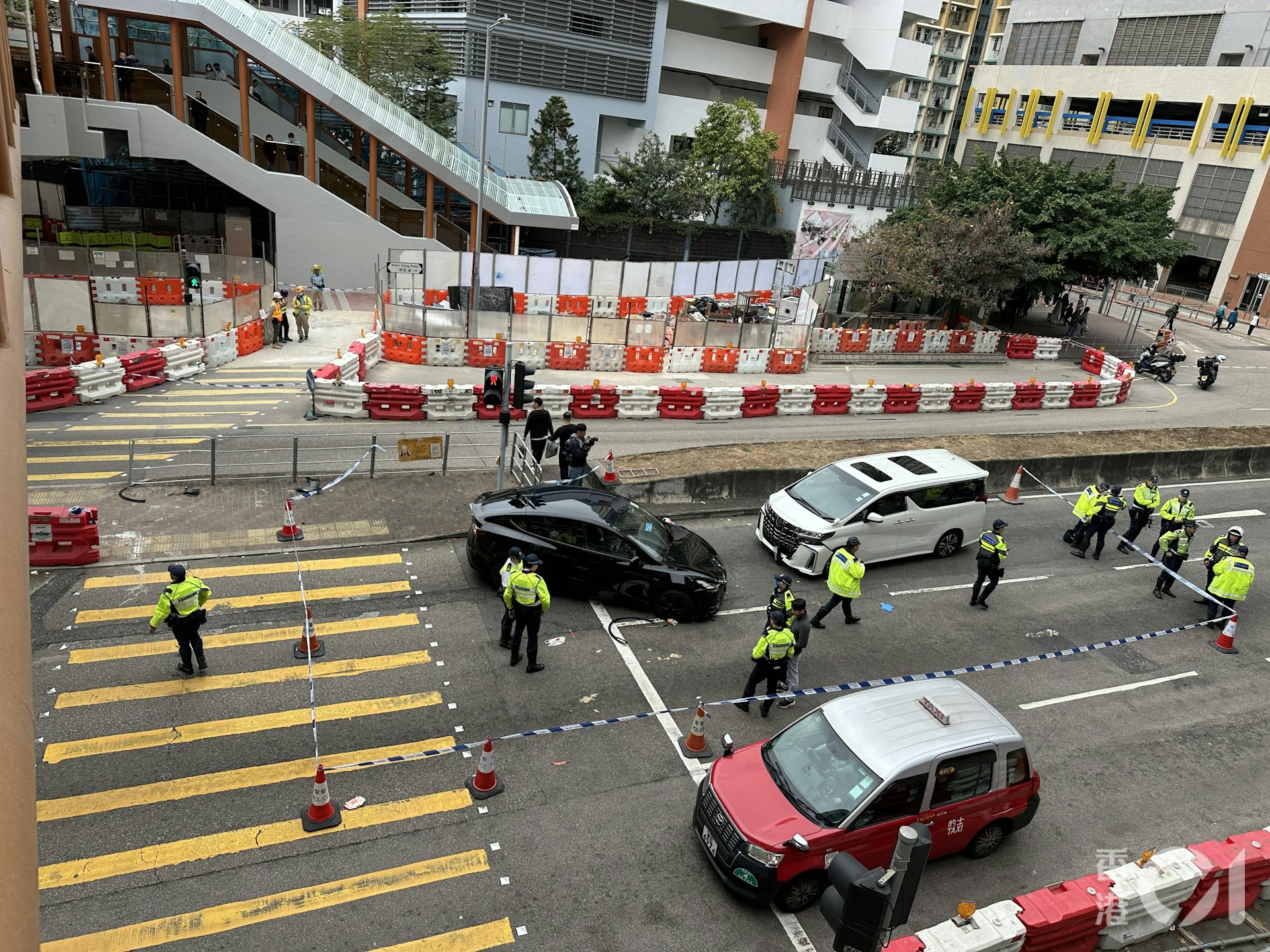 Tesla右轉入深旺道時,失控剷上安全島撞到兩名女學生,再迎頭撞到一輛白色七人車。(黃學潤攝)