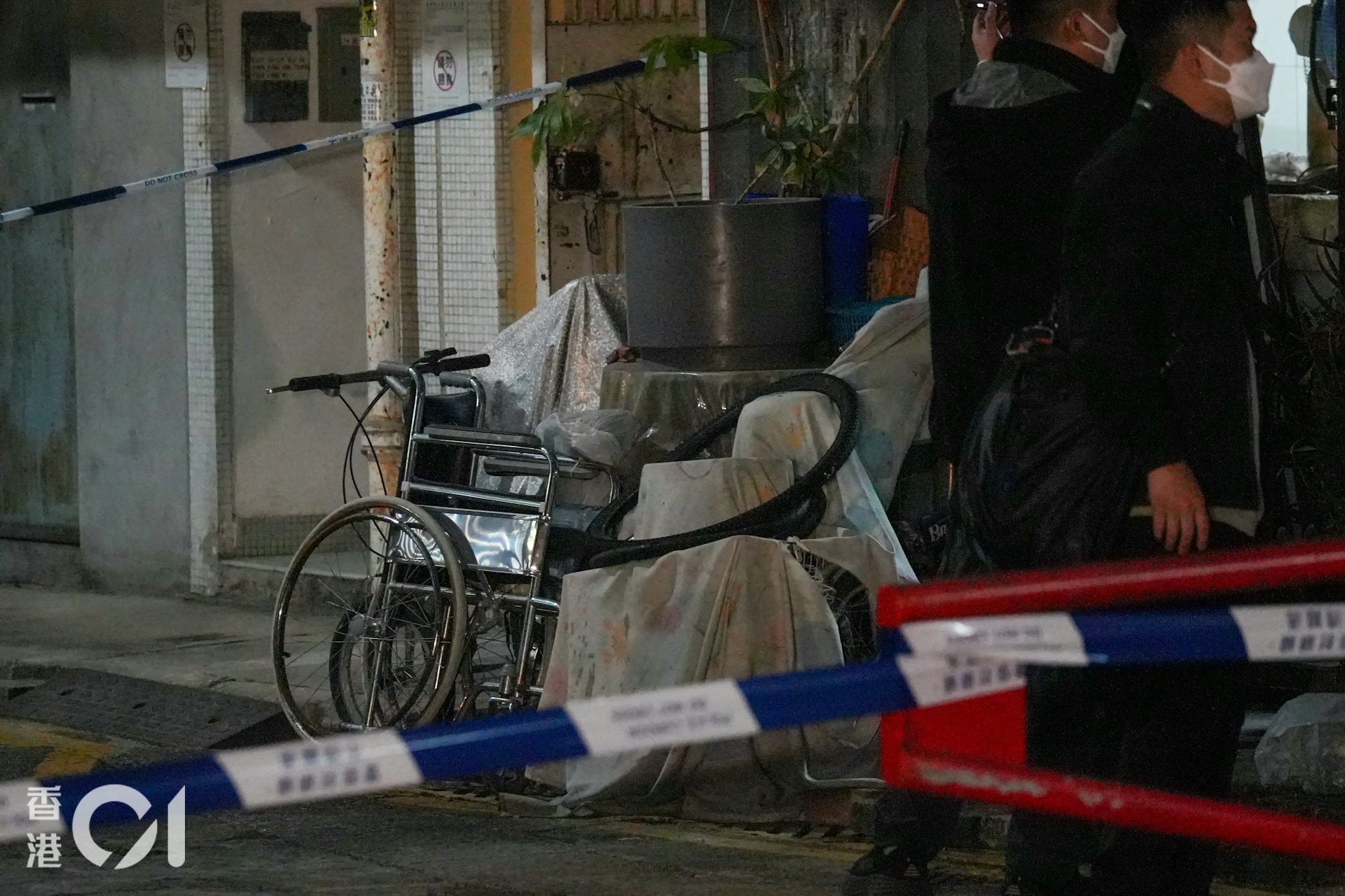 元朗振興新村揭發雙屍案,兩人倒斃在一間村屋內,警員封鎖現場調查,涉事村屋外放有輪椅和雜物。(左朗星攝)