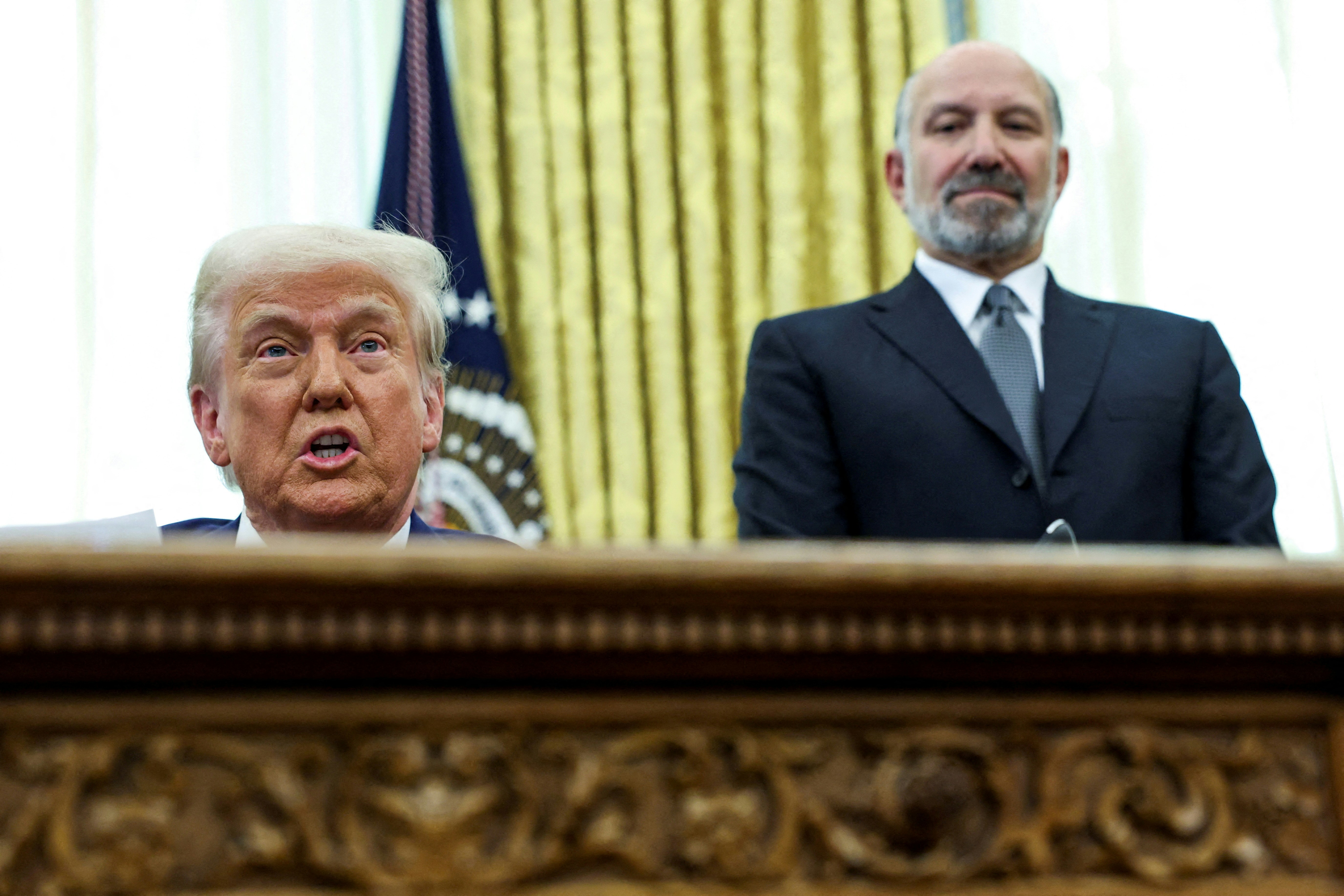 圖為2025年2月13日,美國總統特朗普(Donald Trump)簽署行政令,宣布將實施對等關稅。旁為商務部長(時為提名人)盧特尼克(Howard Lutnick)。(Reuters)