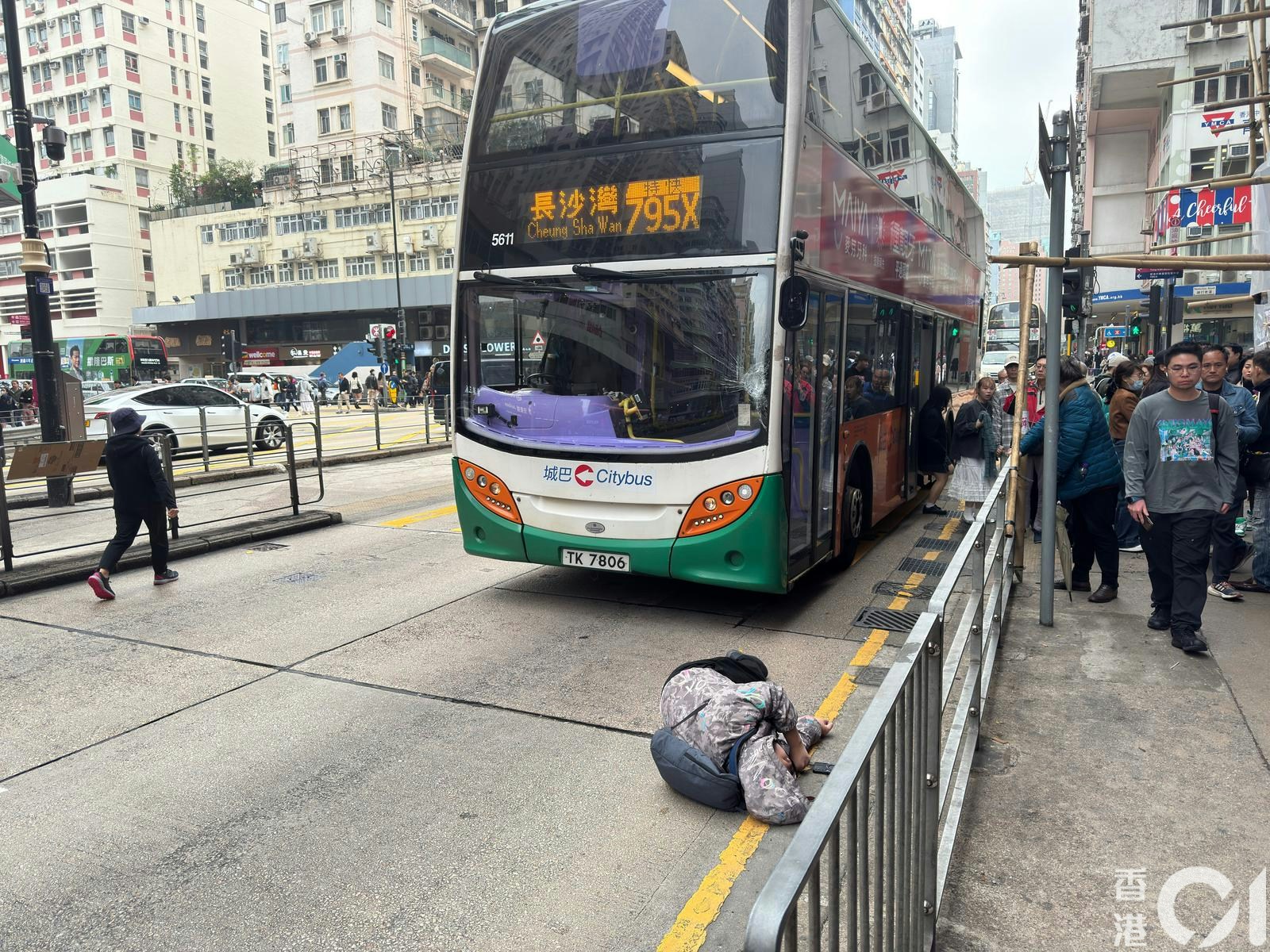 男傷者倒臥馬路邊，巴士左邊擋風玻璃呈「蜘蛛網」爆裂。（目擊者李先生提供）