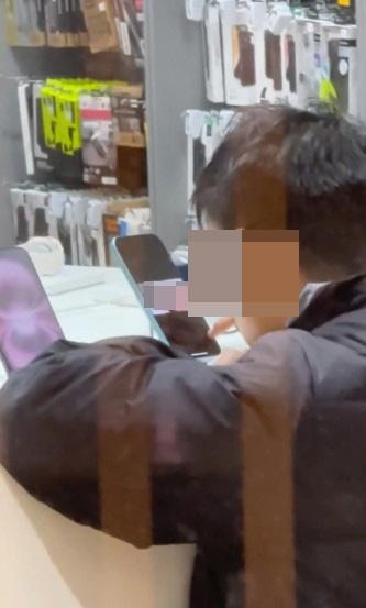 屯門有疑似穿校服的學生哥，被拍到使用手機經銷店陳列的iPhone看AV。（threads影片截圖）