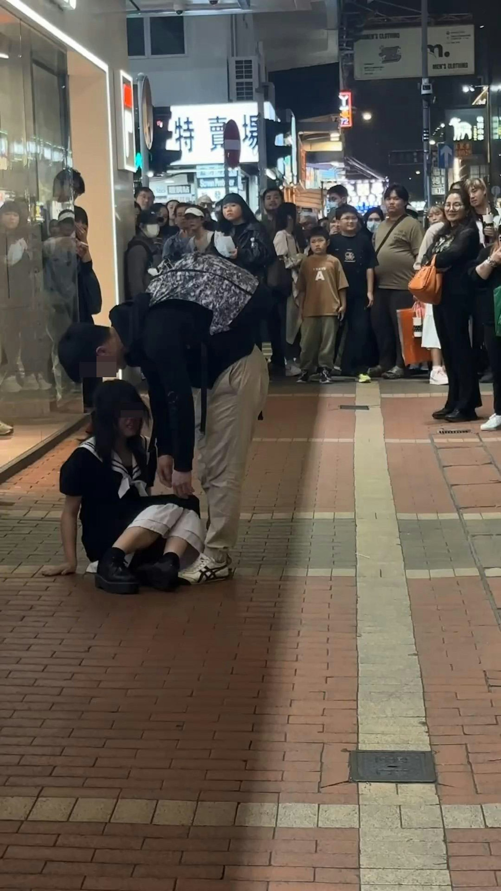 長髮女生坐在地上,疑似男友想扶她起身,惟長髮女大力推開男方,聲嘶力竭咆哮:「走啊!」(影片截圖)