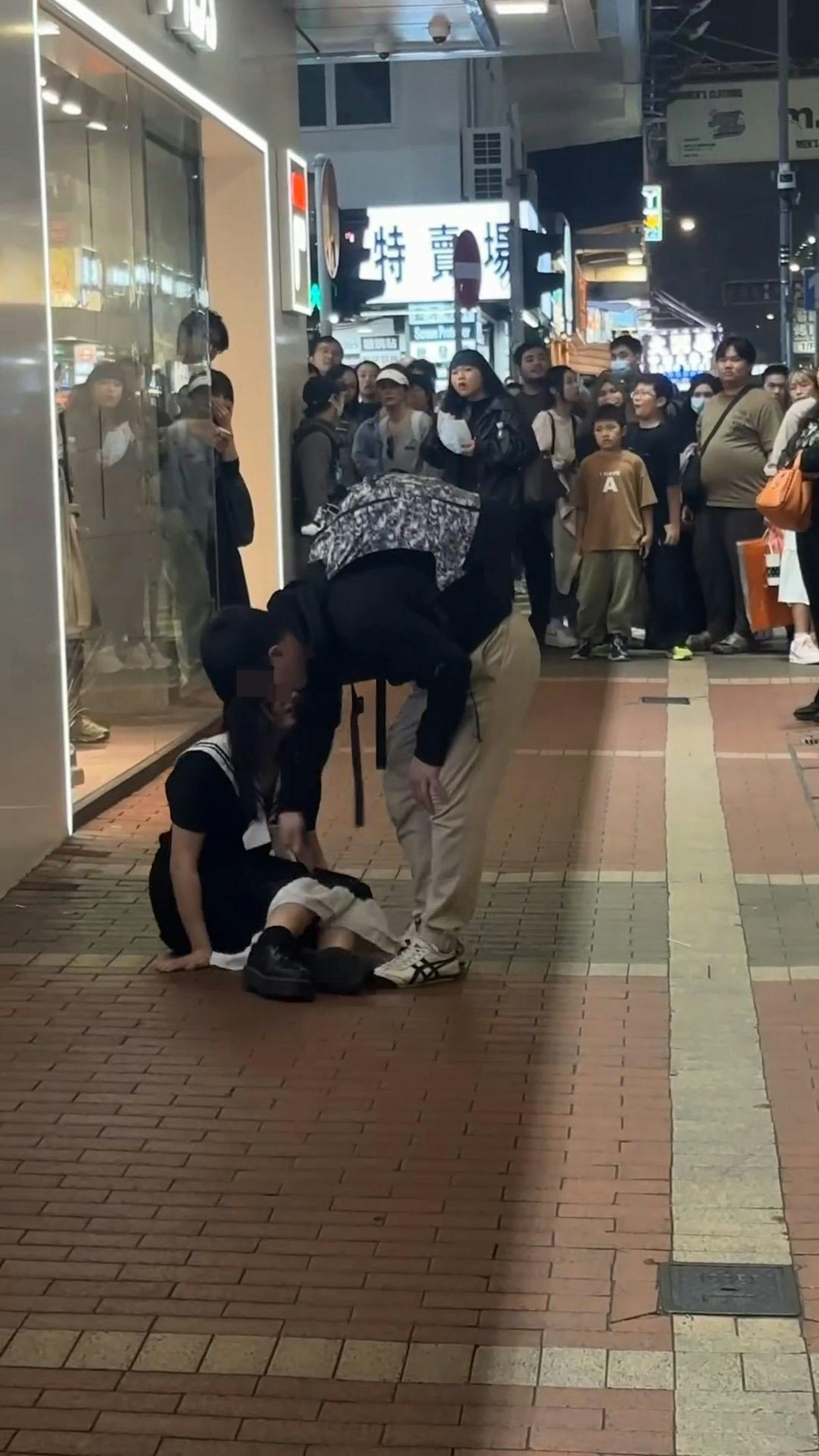 長髮女生坐在地上,疑似男友想扶她起身,惟長髮女大力推開男方,聲嘶力竭咆哮:「走啊!」(影片截圖)