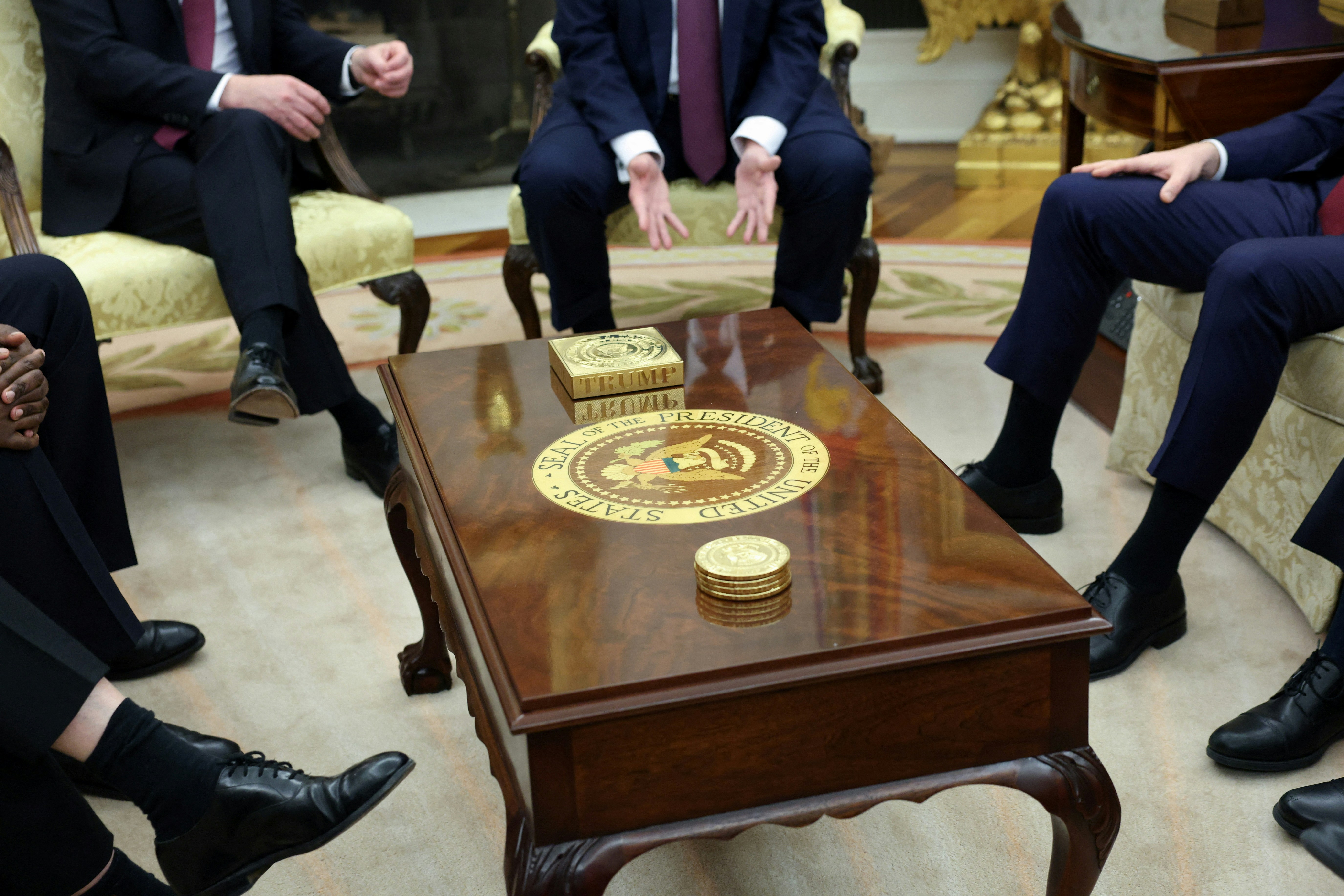 橢圓形辦公室的咖啡桌上,已擺上了印有「特朗普」(TRUMP)字樣的巨大金色鎮紙,和一個金色杯墊。(Reuters)