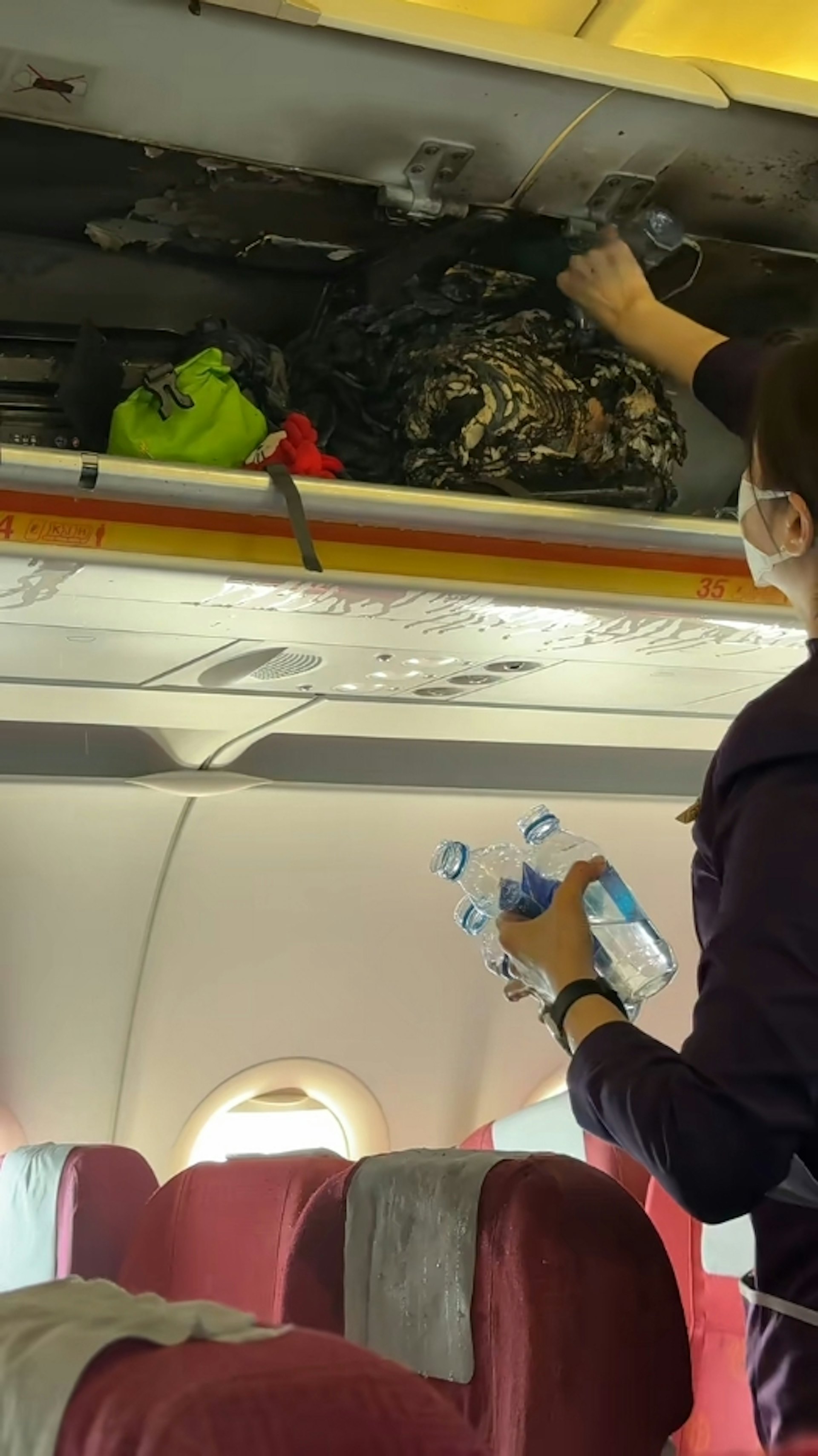 據法國航空事故調查局公布的3月20日杭州飛香港HX115航班起火調查文件,該事故是由充電寶的熱失控引起的,該充電寶已被證實為羅馬仕品牌。圖為乘客及空姐不斷向行李架倒水滅火。(影片截圖) 據法國航空事故調查局公布的3月20日杭州飛香港HX115航班起火調查文件,該事故是由充電寶的熱失控引起的,該充電寶已被證實為羅馬仕品牌。圖為乘客及空姐不斷向行李架倒水滅火。(影片截圖)