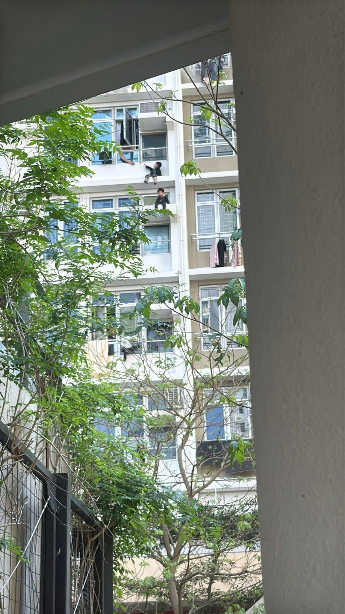 兩名男童危坐外牆石壆及冷氣機位置。（網上圖片）