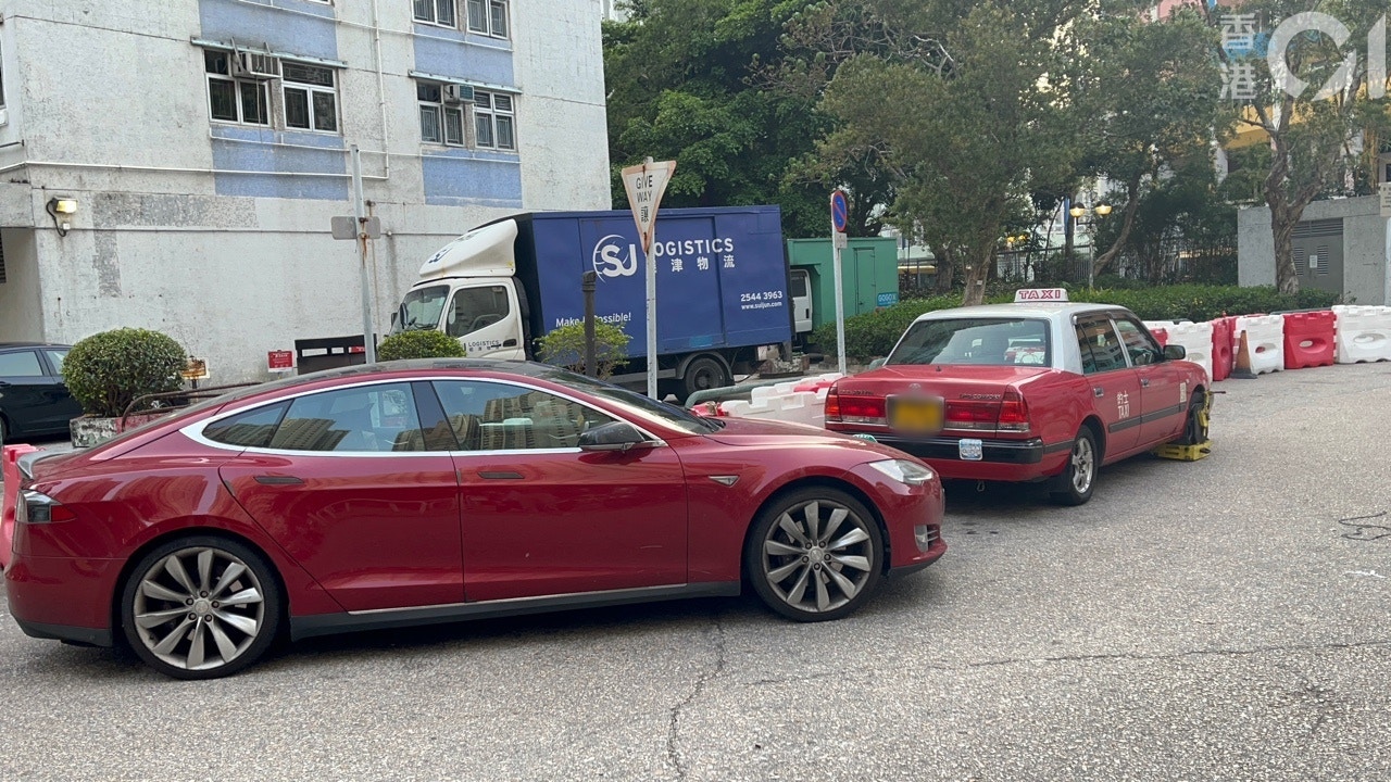 男司機將其TESLA私家車，泊在迴旋處5分鐘後，迅速被保安鎖車。（戴慧豐攝）