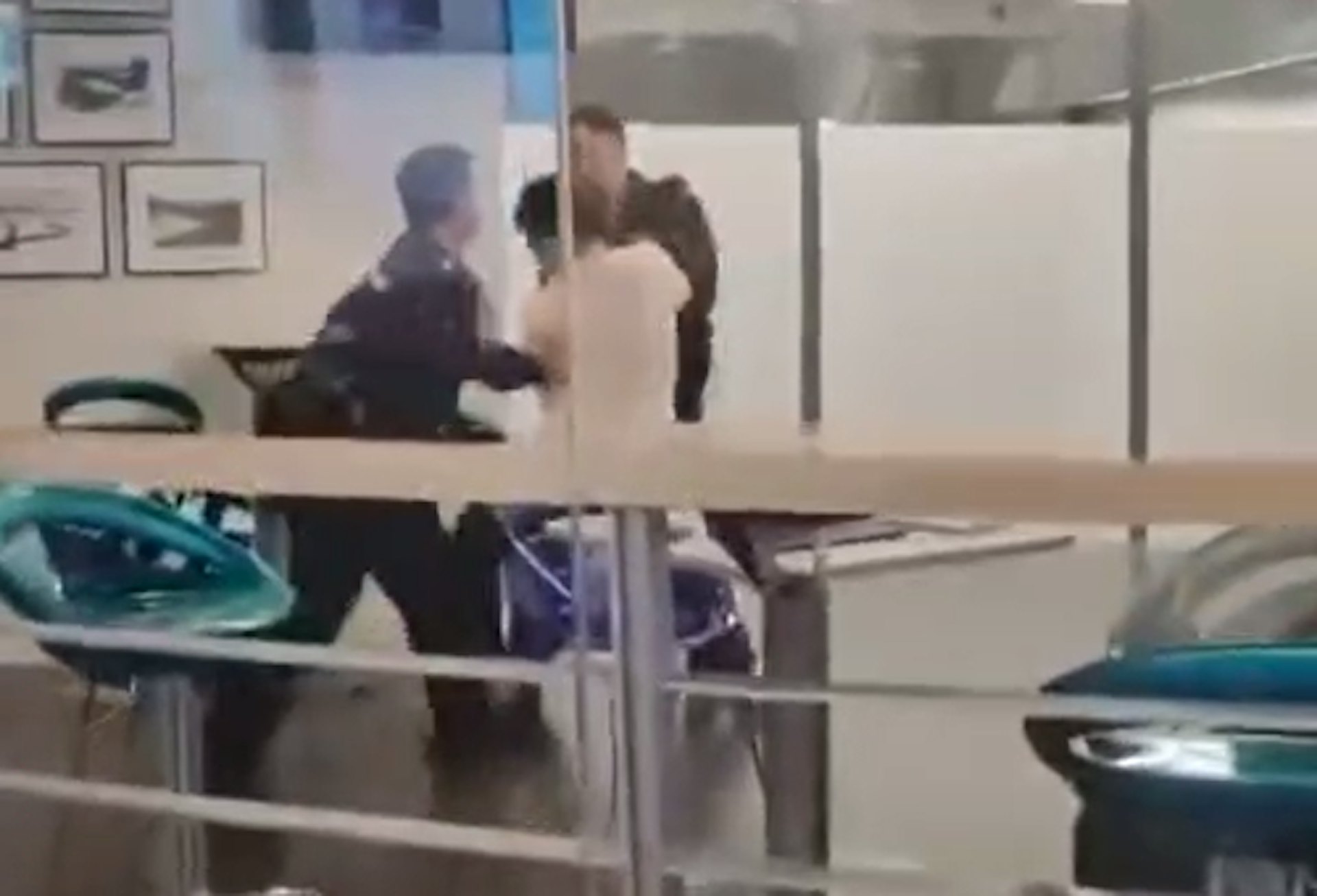 兩名警員與白衫男於城大圖書館內扭打糾纏。(網上影片截圖) 兩名警員與白衫男於城大圖書館內扭打糾纏。(網上影片截圖)
